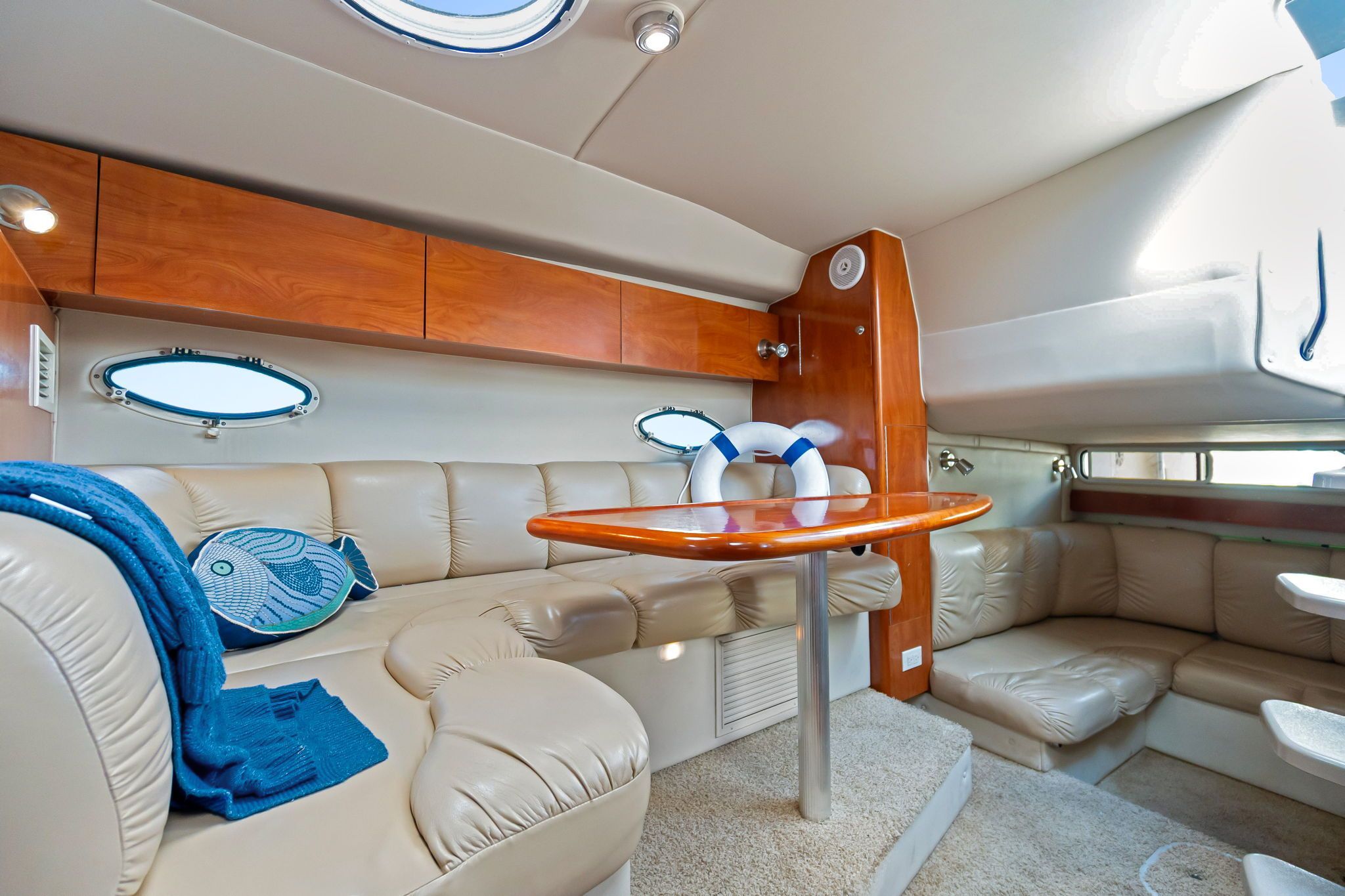 Interior of the 2007 Larson Cabrio 330 with beige leather and wooden table.