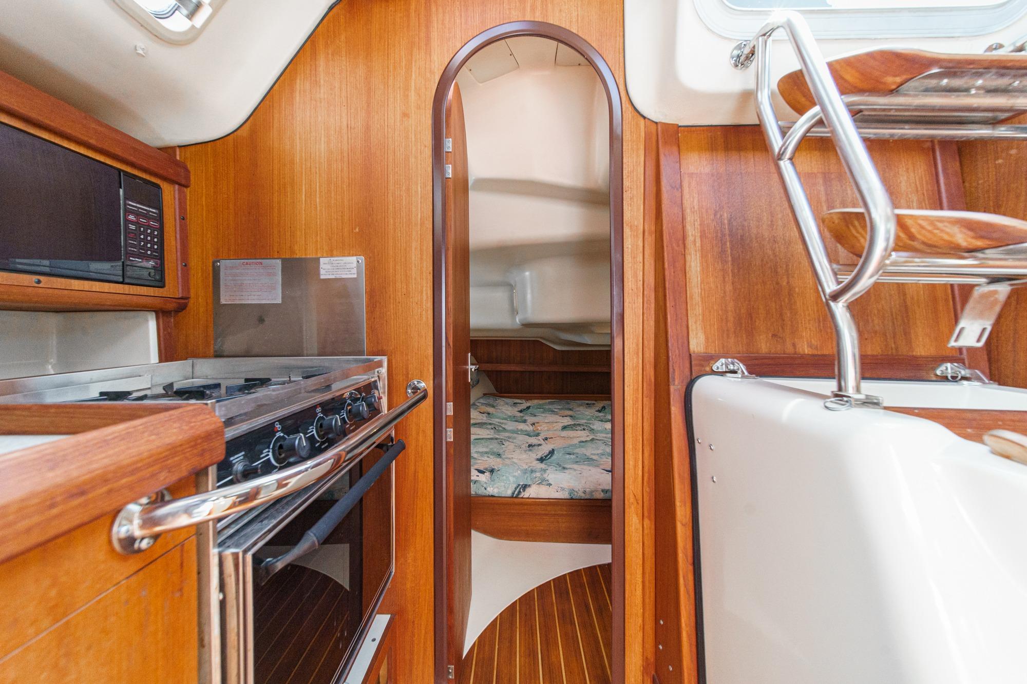Interior of 1996 Hunter 376 sailboat with kitchen and cozy cabin.