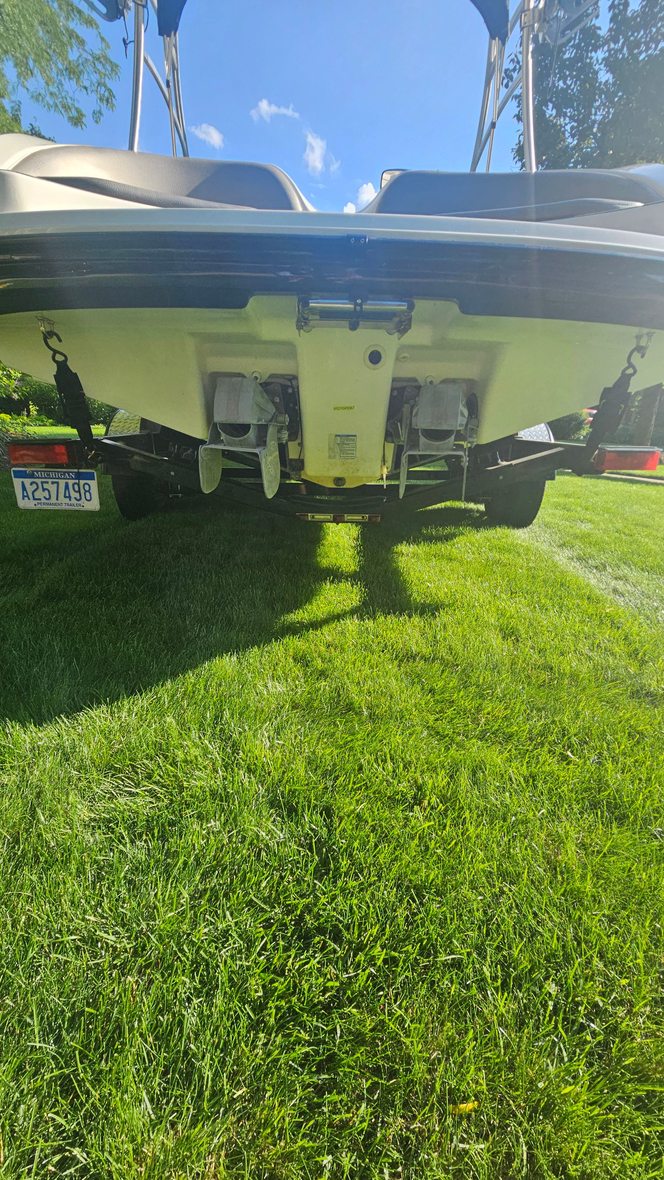 Rear view of a Yamaha AR210 boat on grass, showing the hull and drives.