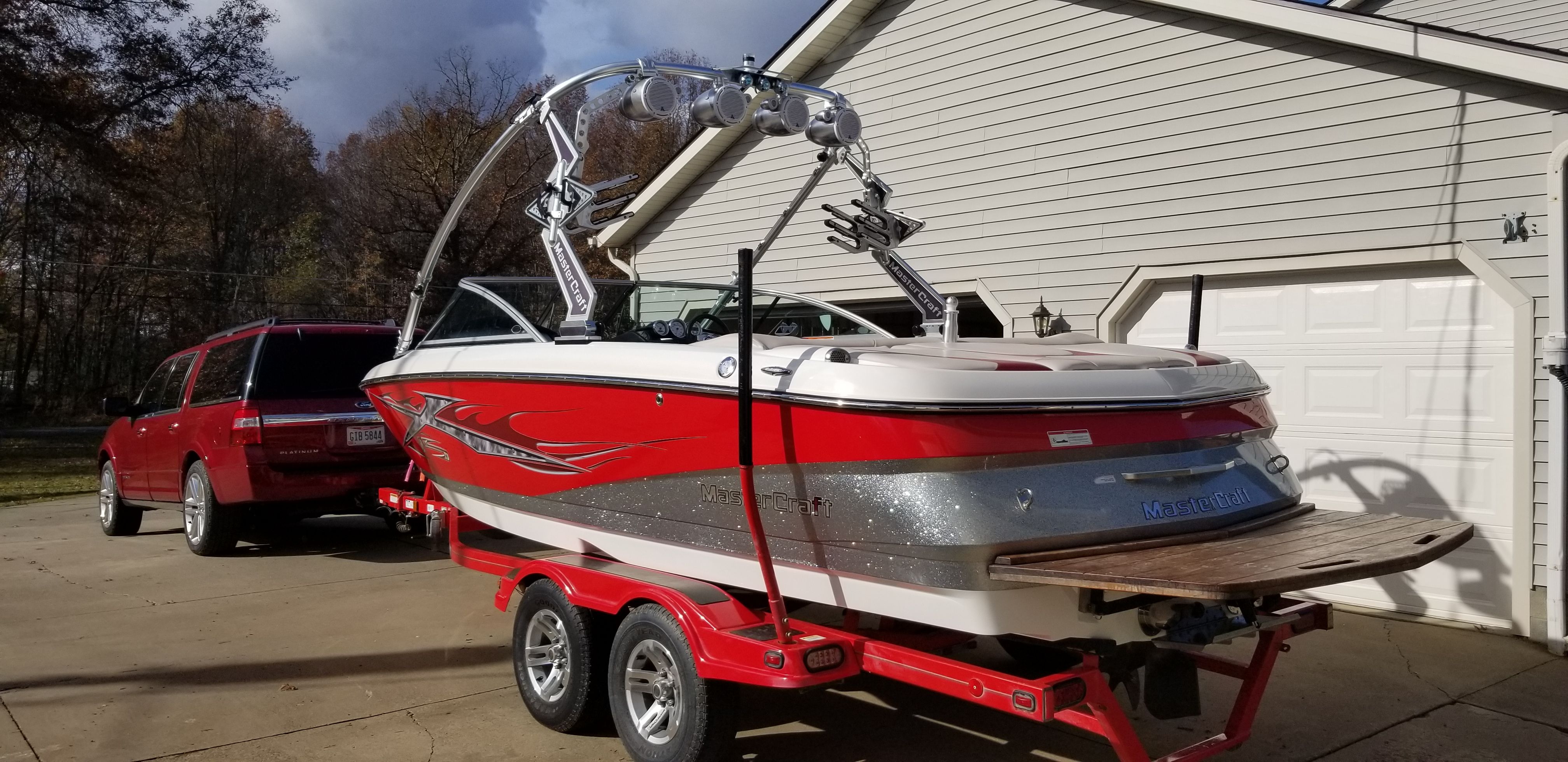 2007 MasterCraft X-15 boat on trailer in front of garage.