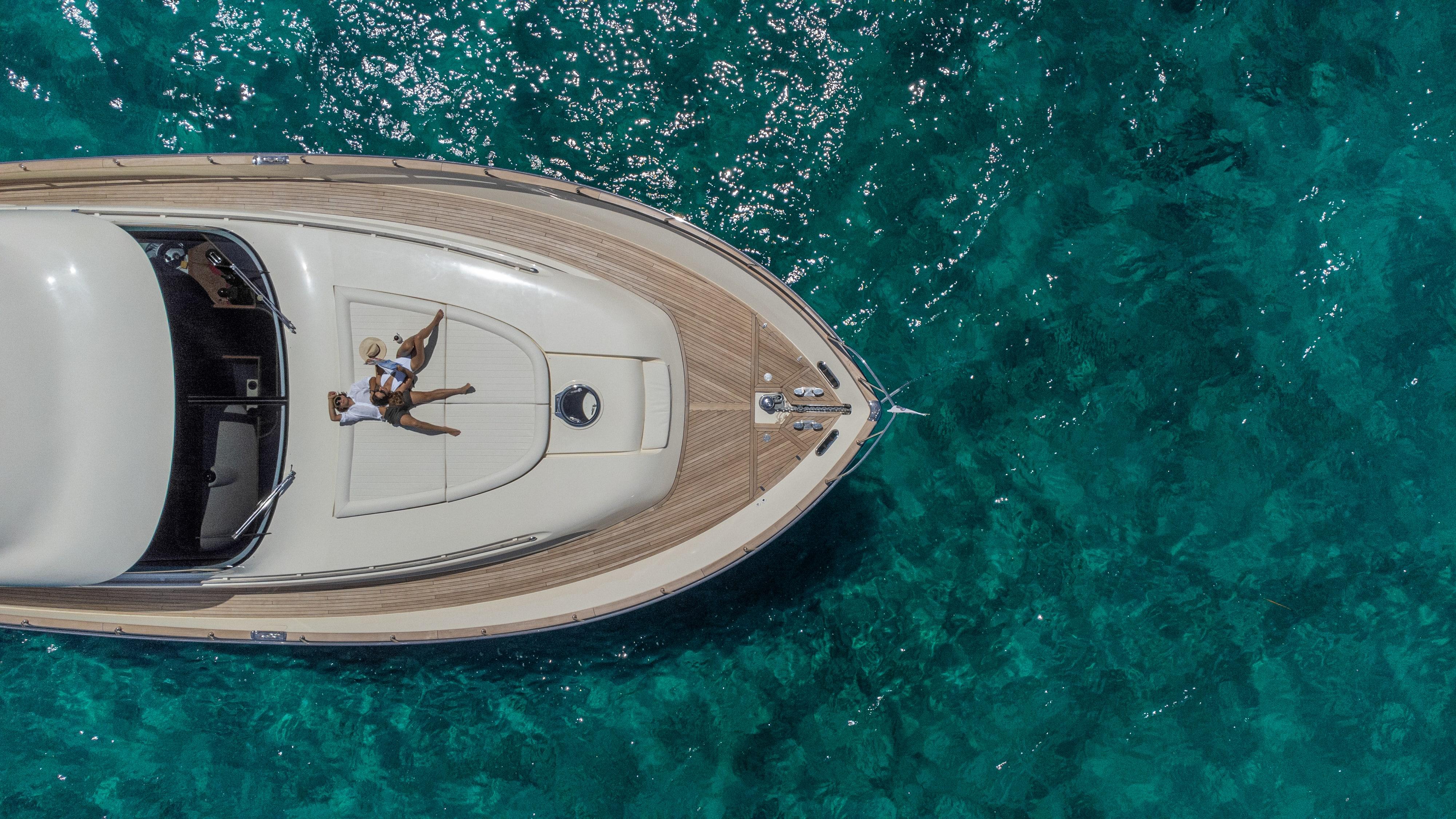 Aerial view of 2005 Mochi Craft 74' Dolphin yacht on clear turquoise water.