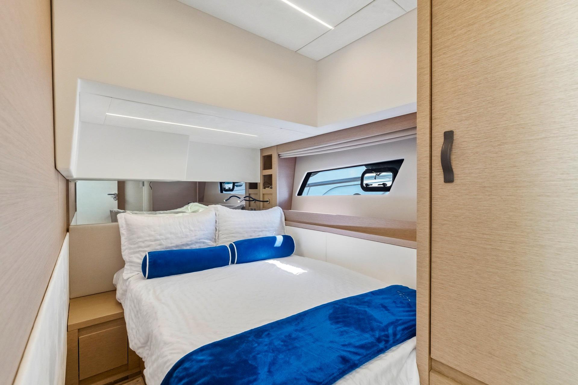 Luxurious cabin interior of 2022 Prestige 520 yacht with elegant bedding and modern design.