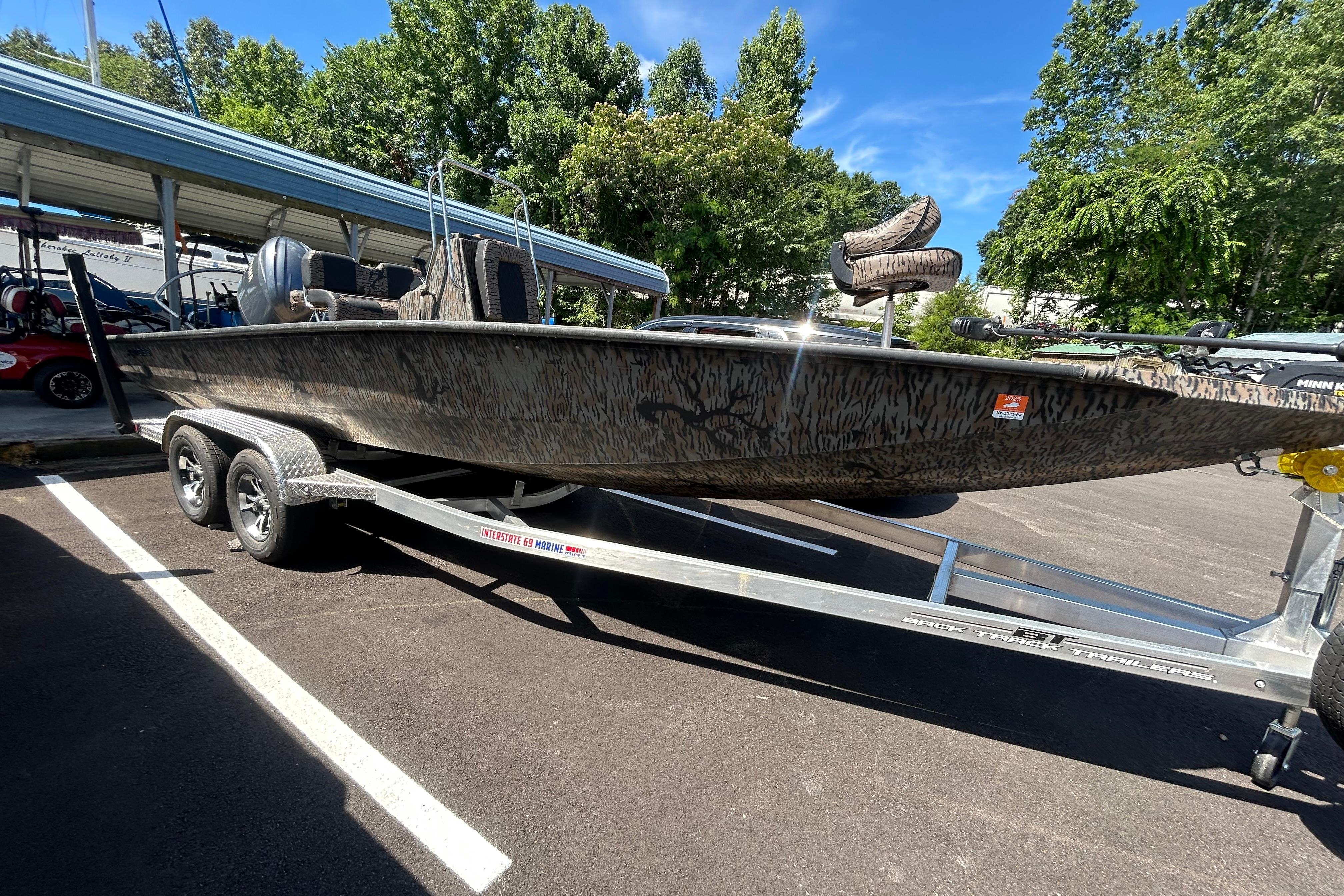 2025 Xpress H22B Bay boat on trailer, parked outdoors under clear sky.