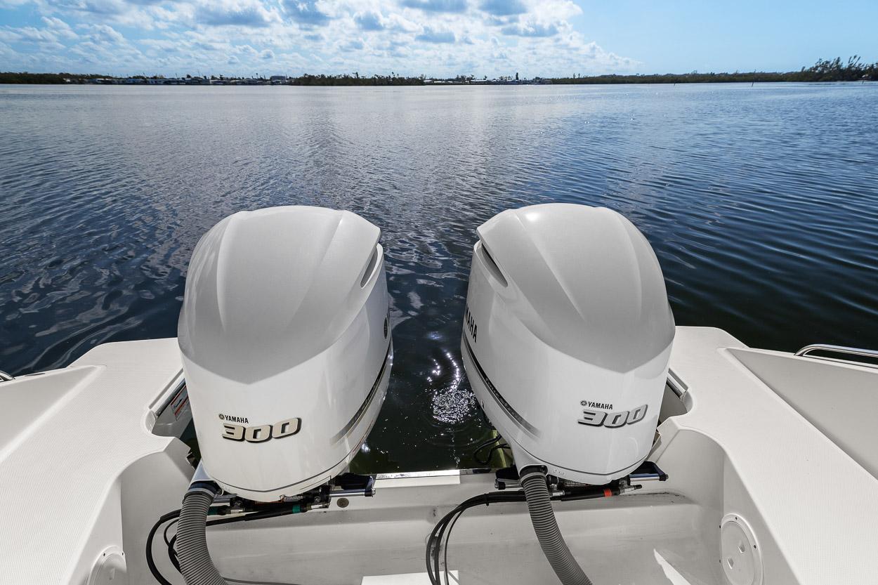 2021 Pursuit S 328 Sport boat with twin 300 horsepower engines on a calm lake.