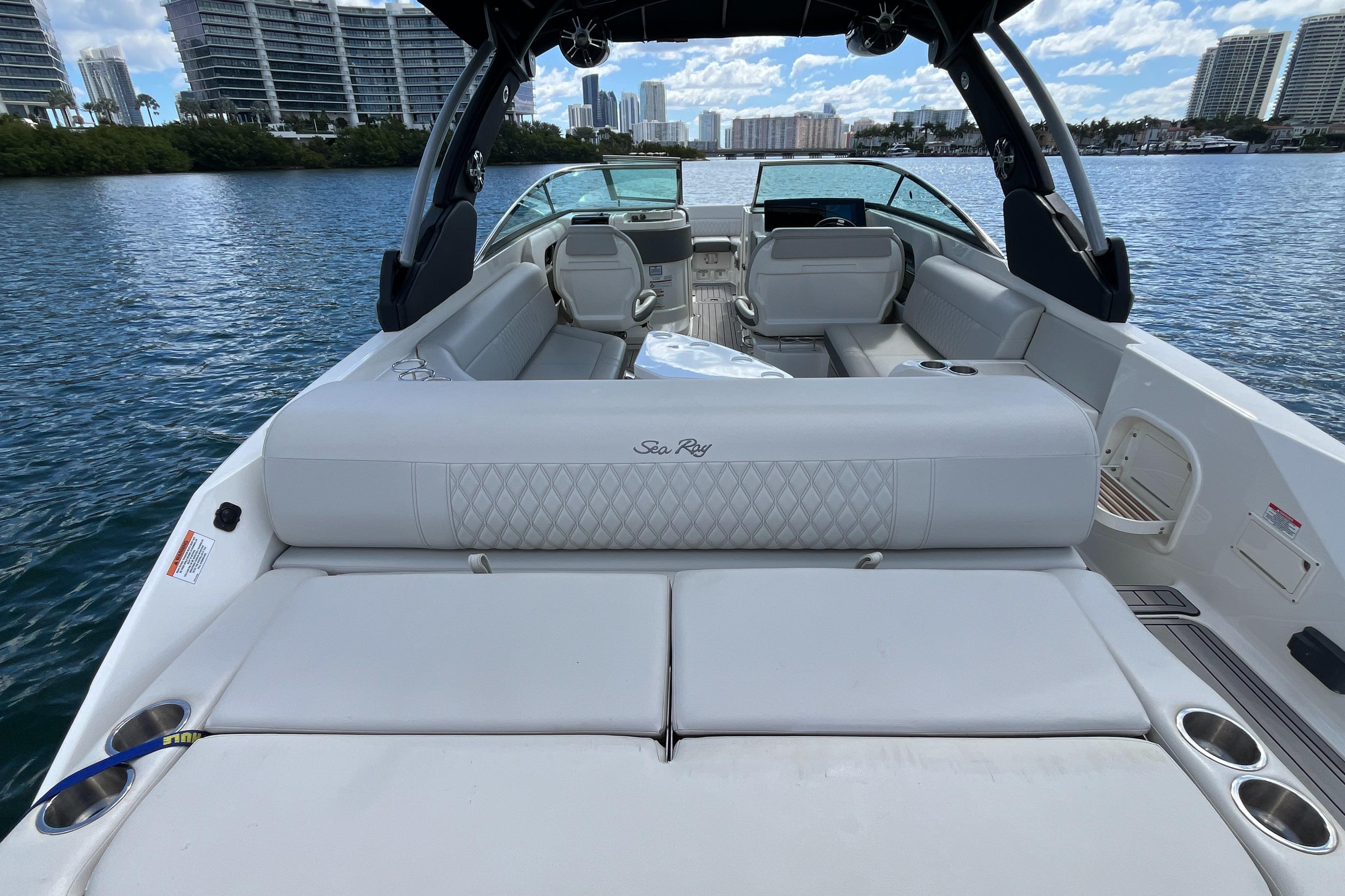 2021 Sea Ray SLX 280 boat interior with luxurious seating on a calm waterway.
