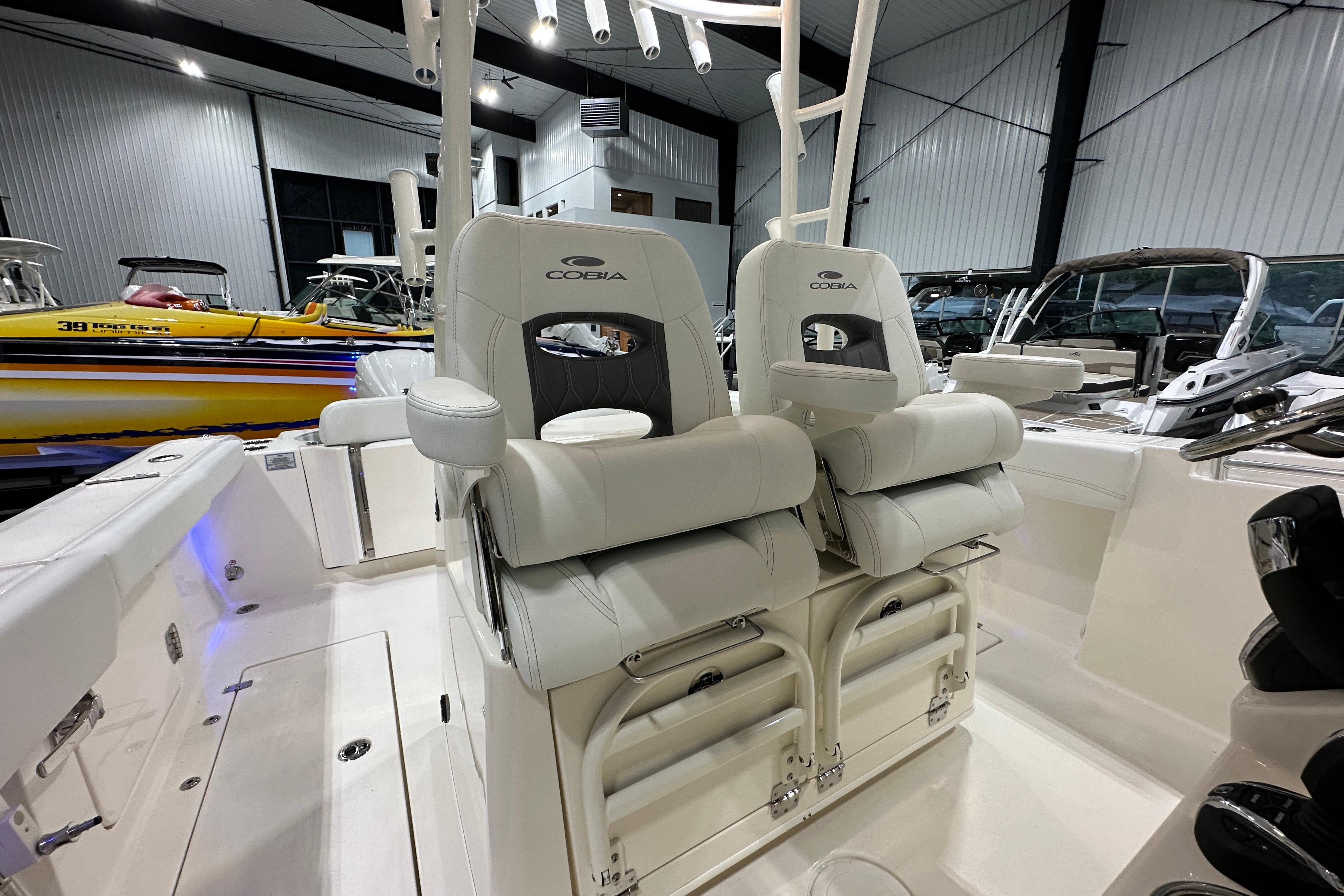 2024 Cobia 301 Center Console boat interior with plush seating in a showroom.