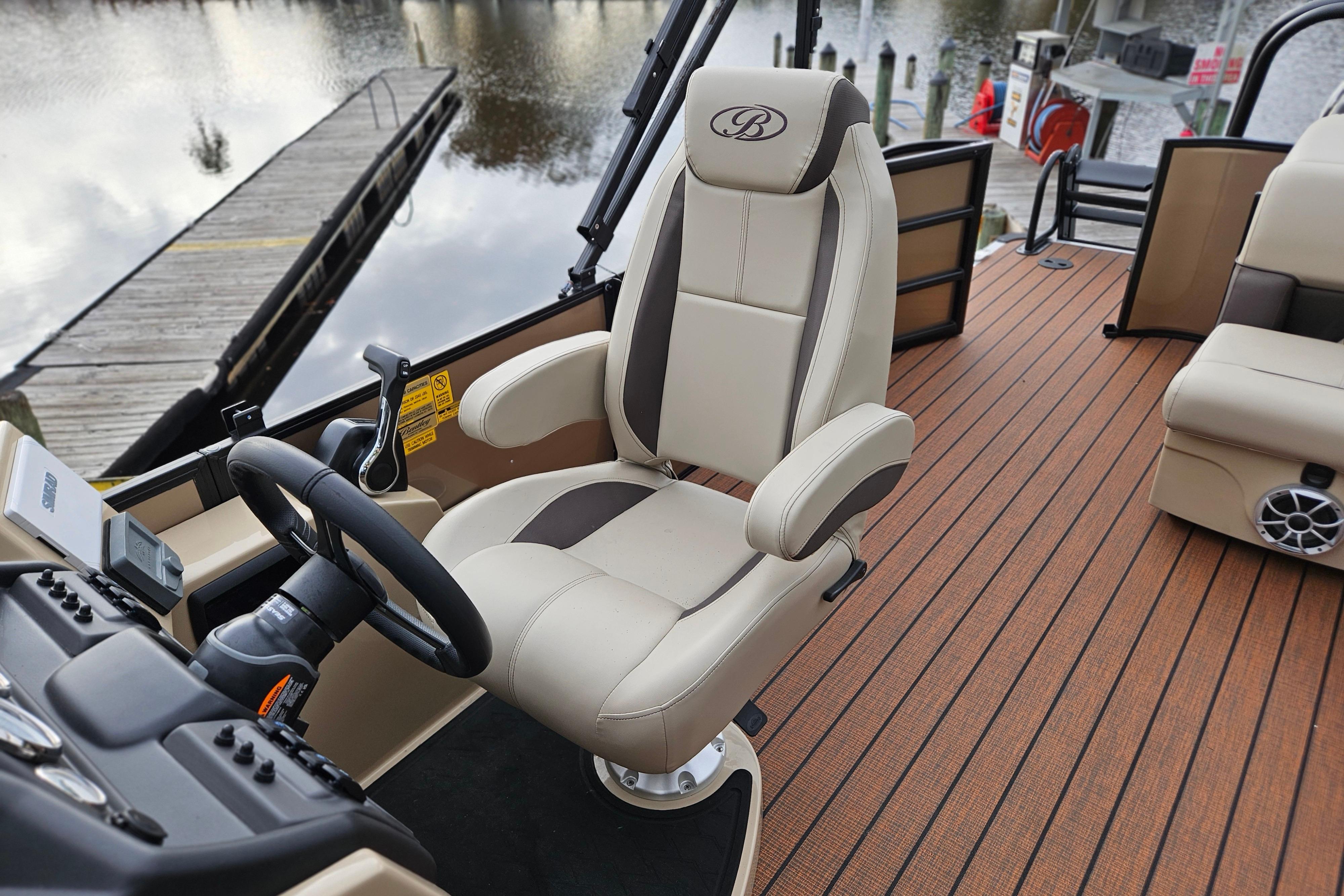 2026 Bentley Pontoons Legacy 243 Cruise interior with luxurious captain's chair and wood-style flooring.