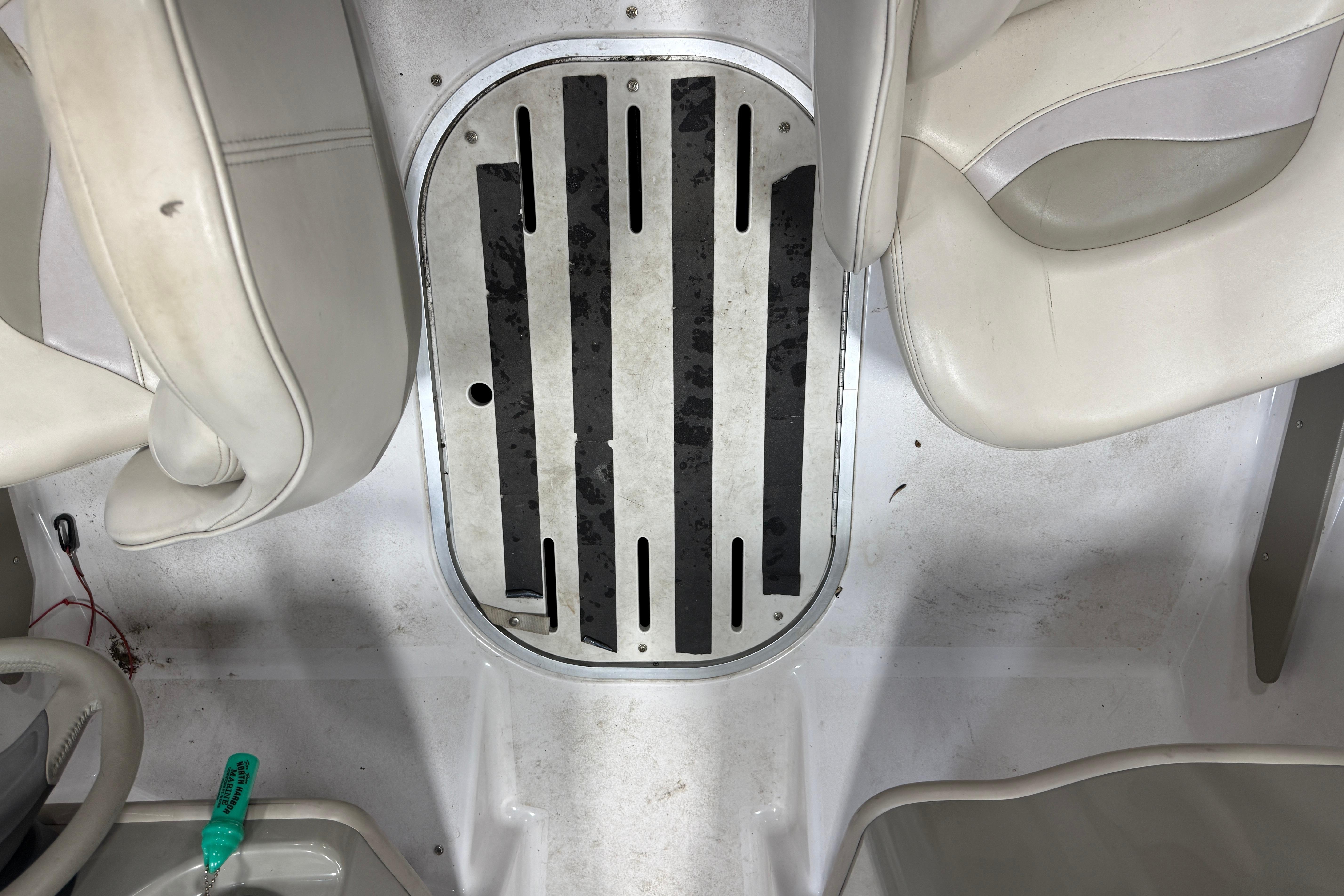 Interior of a 1999 Four Winns 170 Horizon LE boat, featuring white seating and floor details.