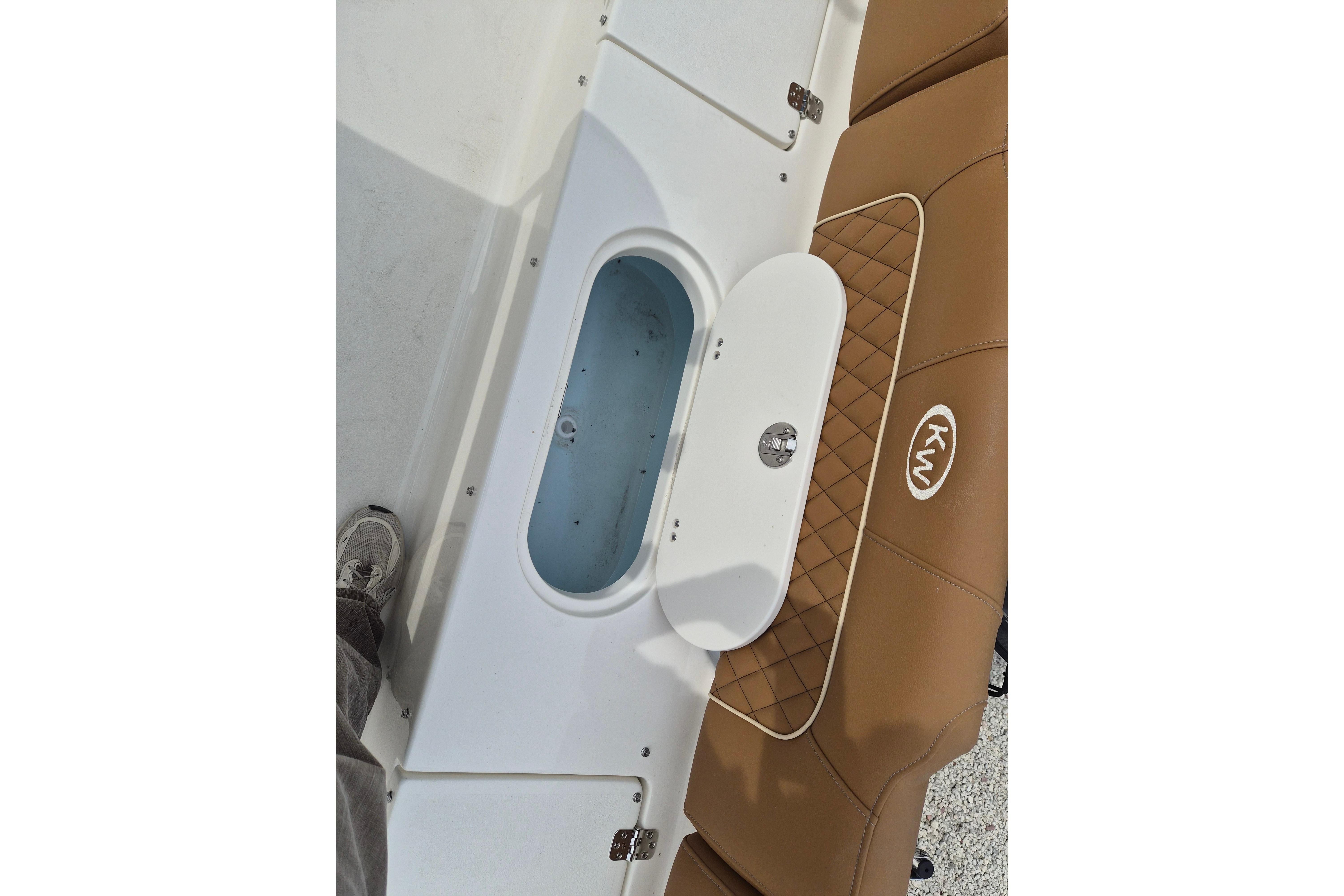 2026 Key West 189 FS boat interior with tan seating and storage compartment.