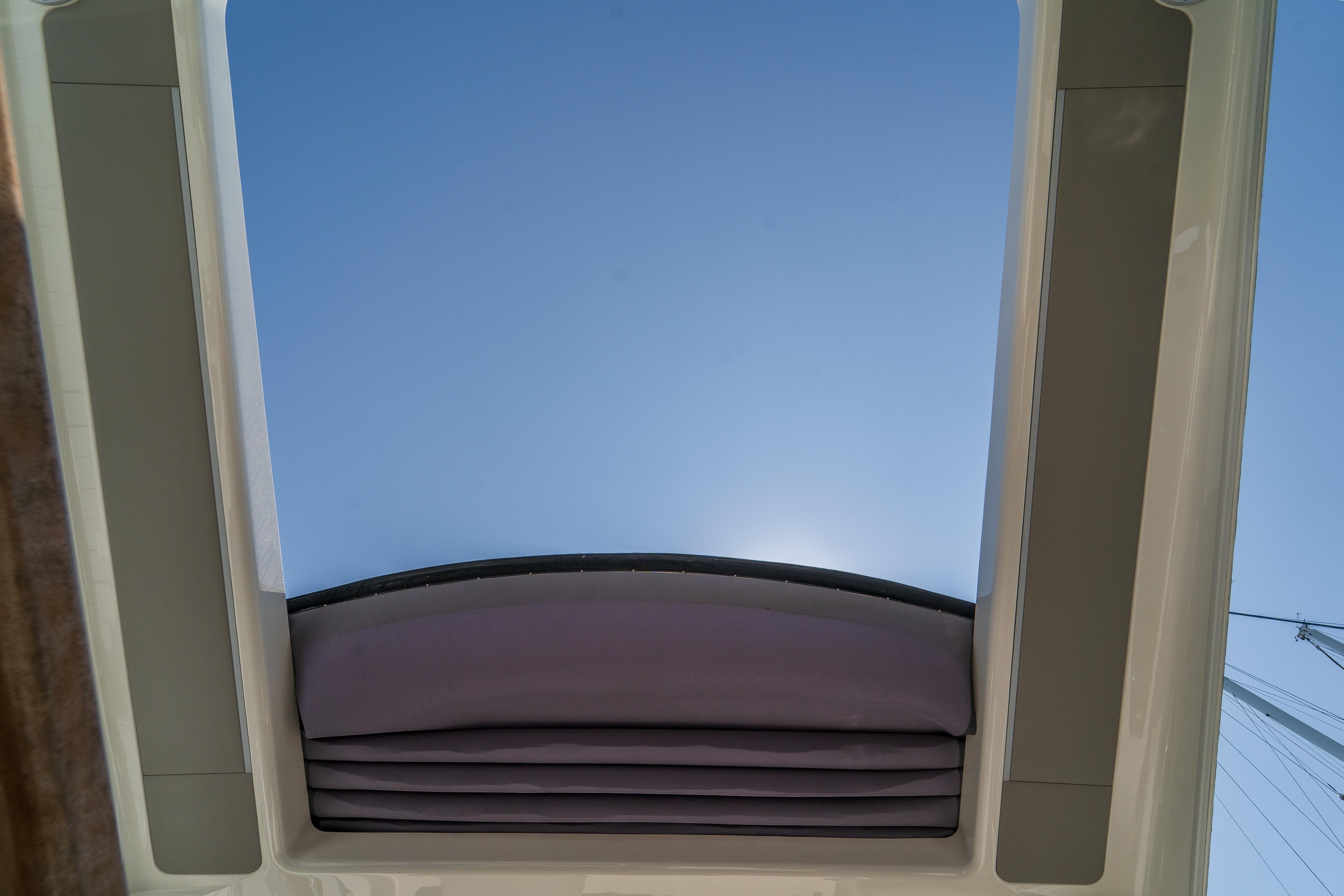 Sunroof view from 2023 Absolute 62 Fly yacht, showcasing clear blue sky.