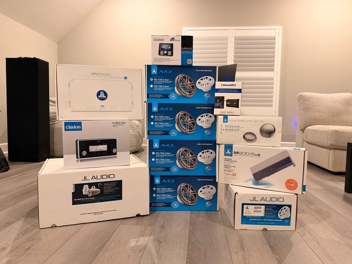 Audio and speaker accessories for a boat, stacked in a room.
