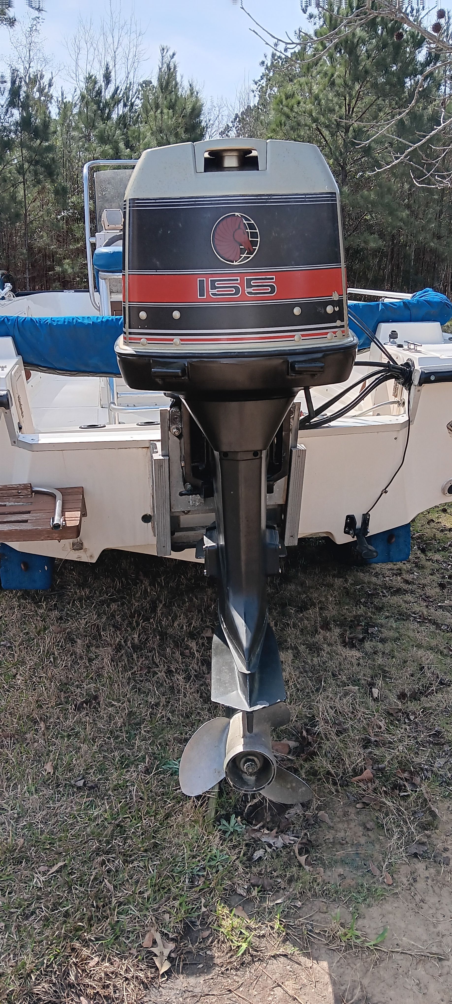 Outboard motor of a 1990 Hydra-Sports Vector boat, parked on grass.