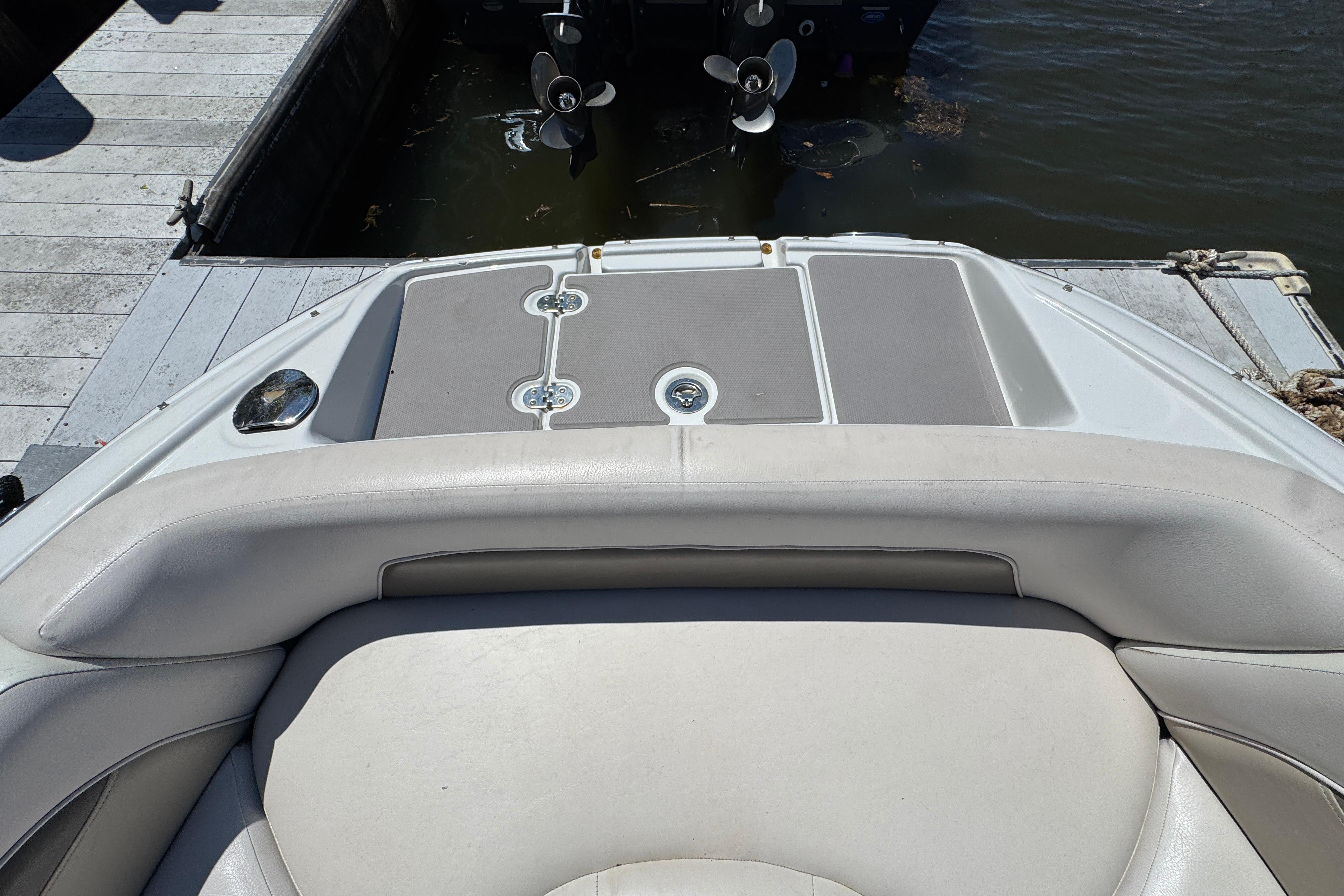 2013 Crownline Eclipse E6 XS boat interior, featuring cushioned seating and swim platform by the dock.