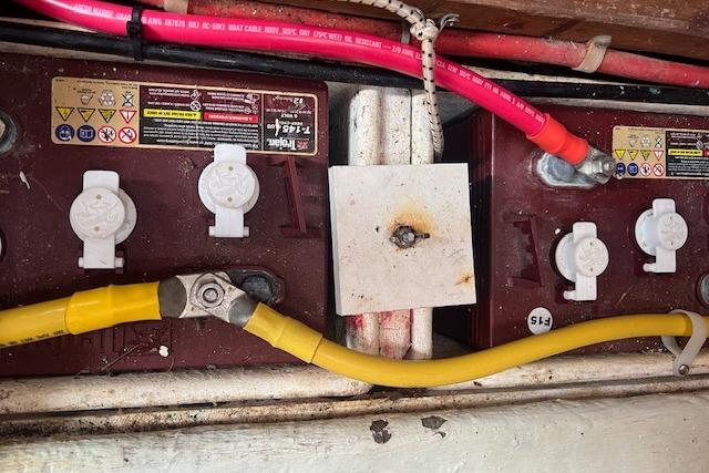 Battery compartment of 1986 Little Harbor AFt Cockpit K/CB Sloop with cables and connectors.