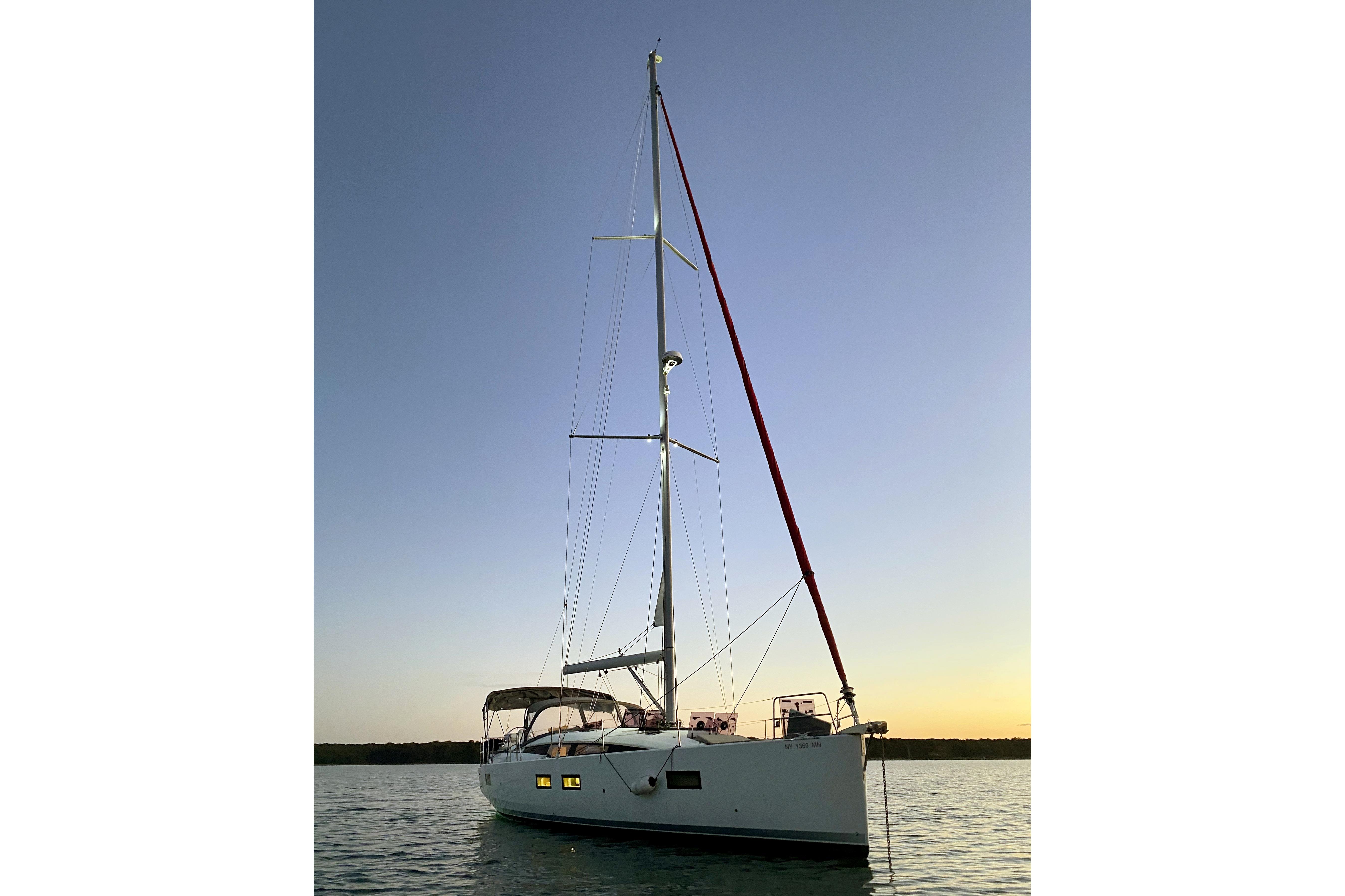 2018 Jeanneau 51 sailboat at sunset on calm waters.