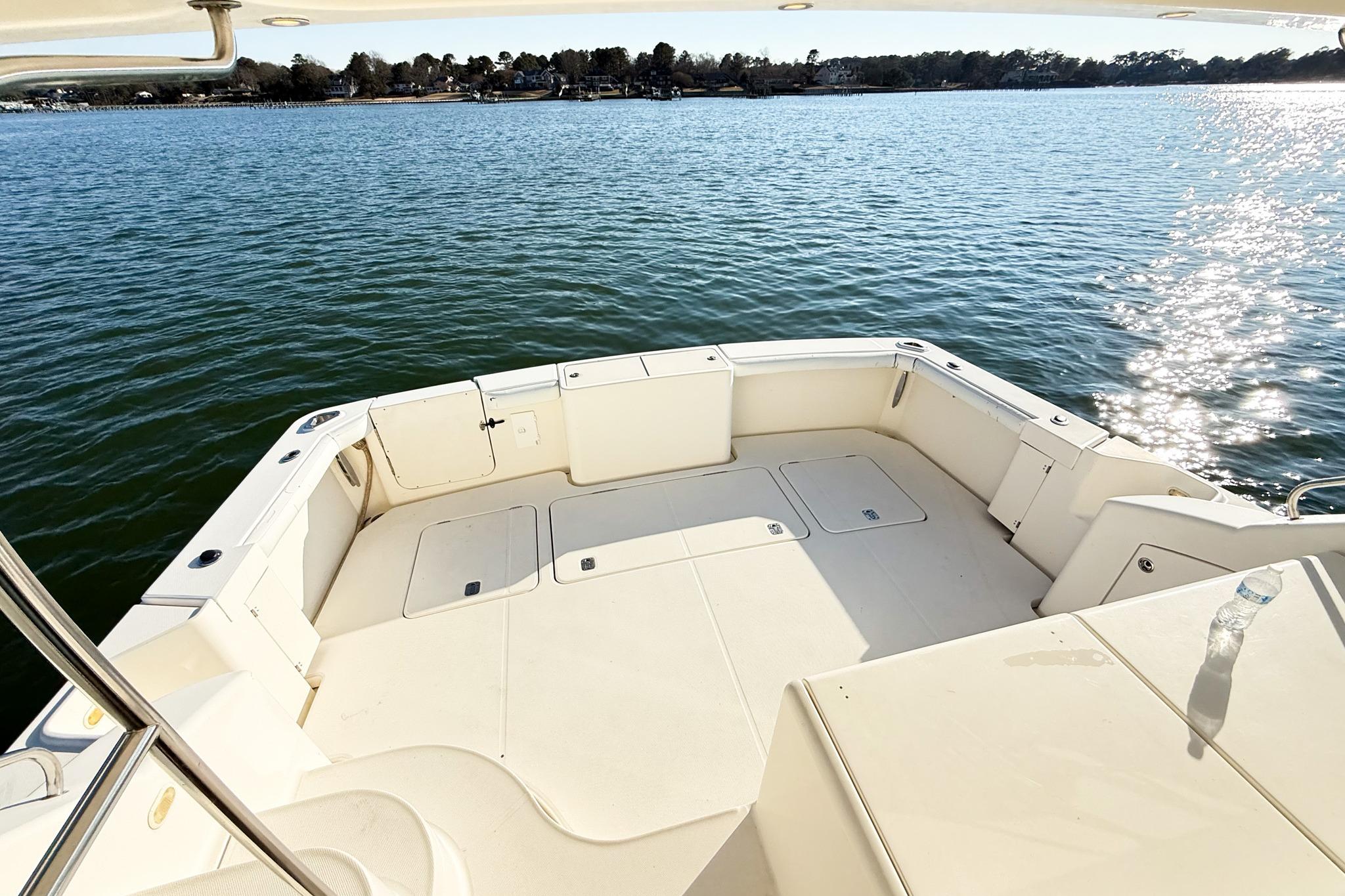 2004 Silverton 48 Convertible yacht deck overlooking serene water and distant shoreline.