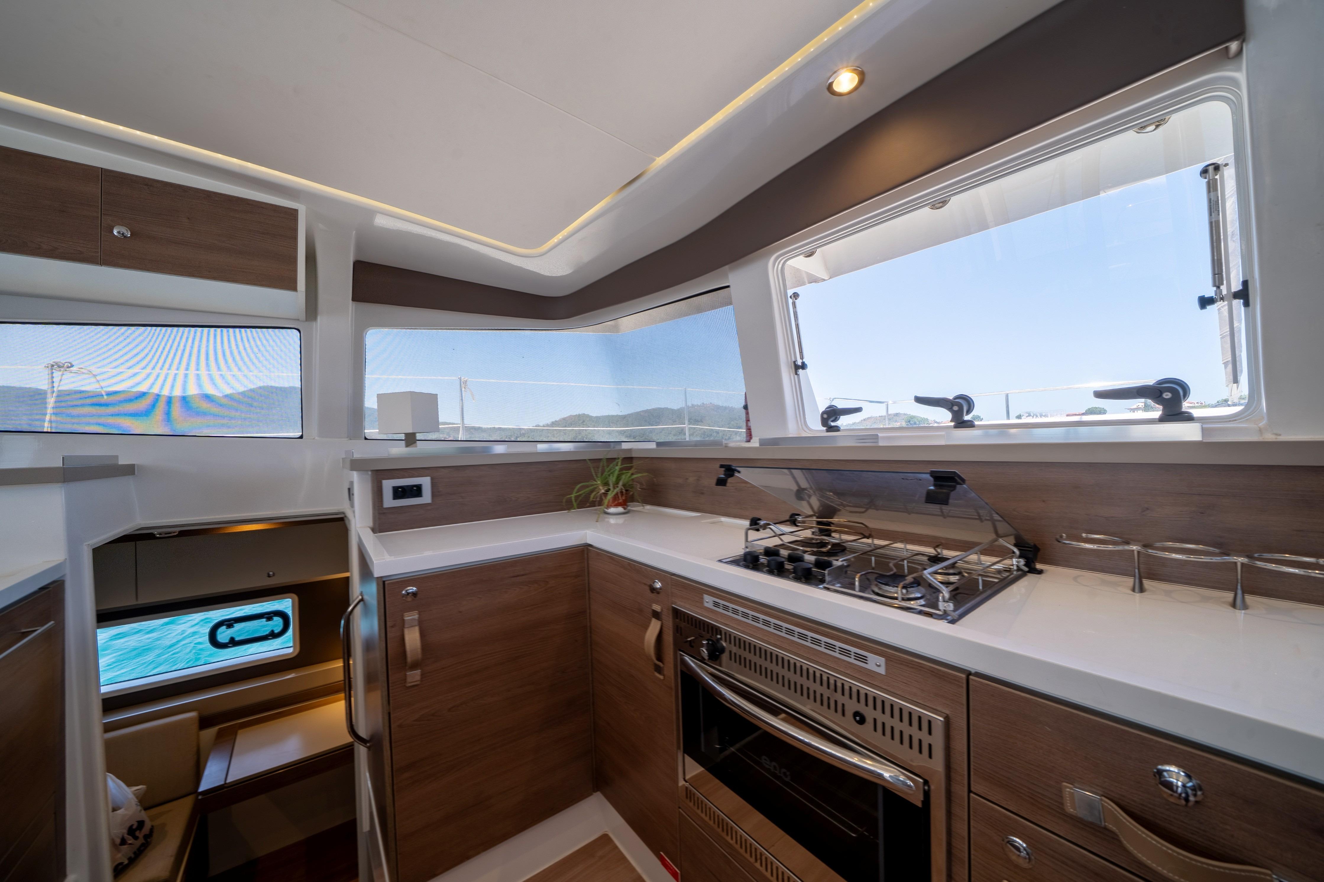Modern kitchen interior on 2022 Bali 4.2 yacht with stove and scenic windows.