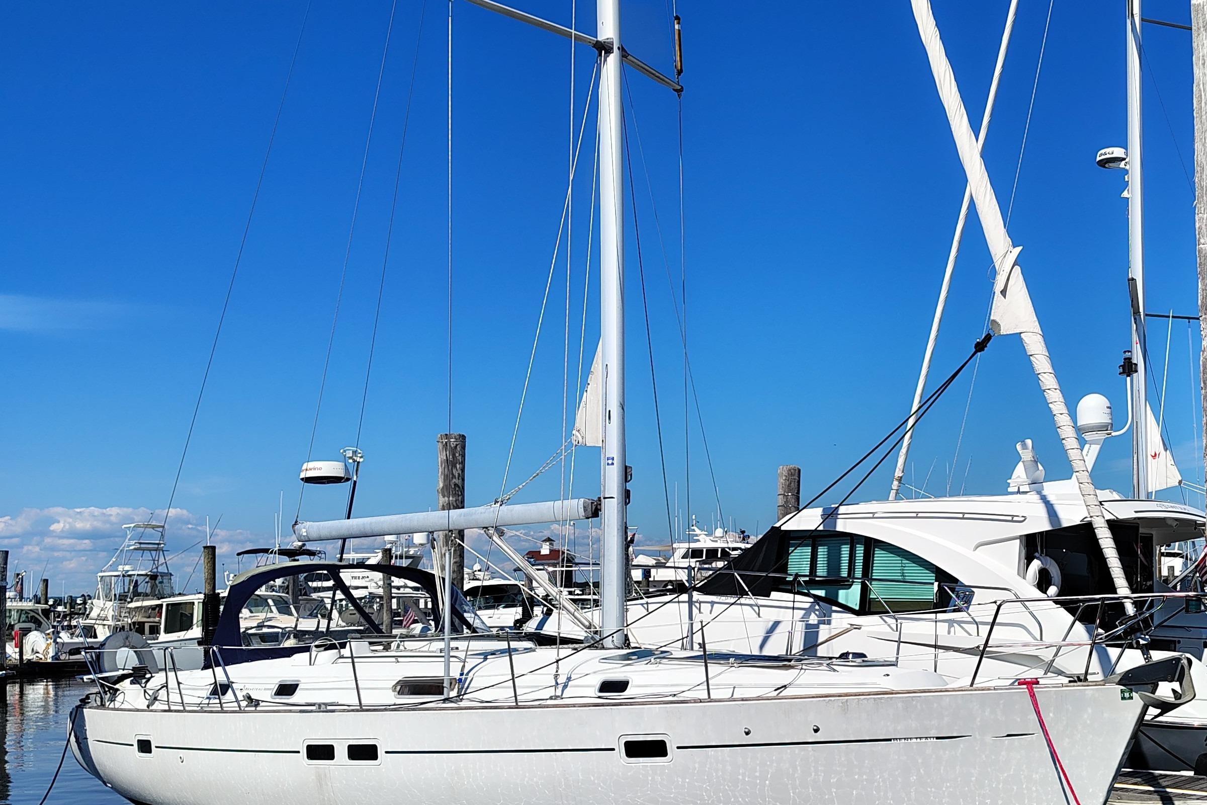 2001 Beneteau Oceanis 411 sailboat docked in a marina under clear blue skies.