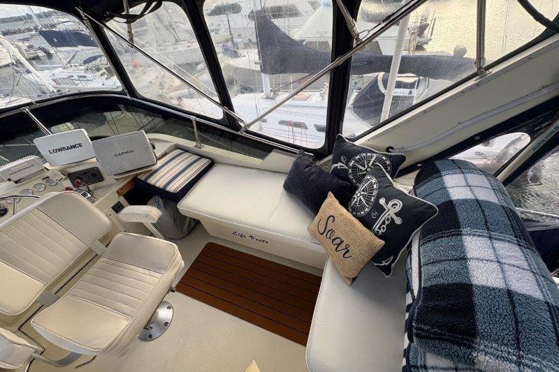 1987 Tollycraft 34 Sundeck Motor Yacht interior with seating, cushions, and navigation equipment.