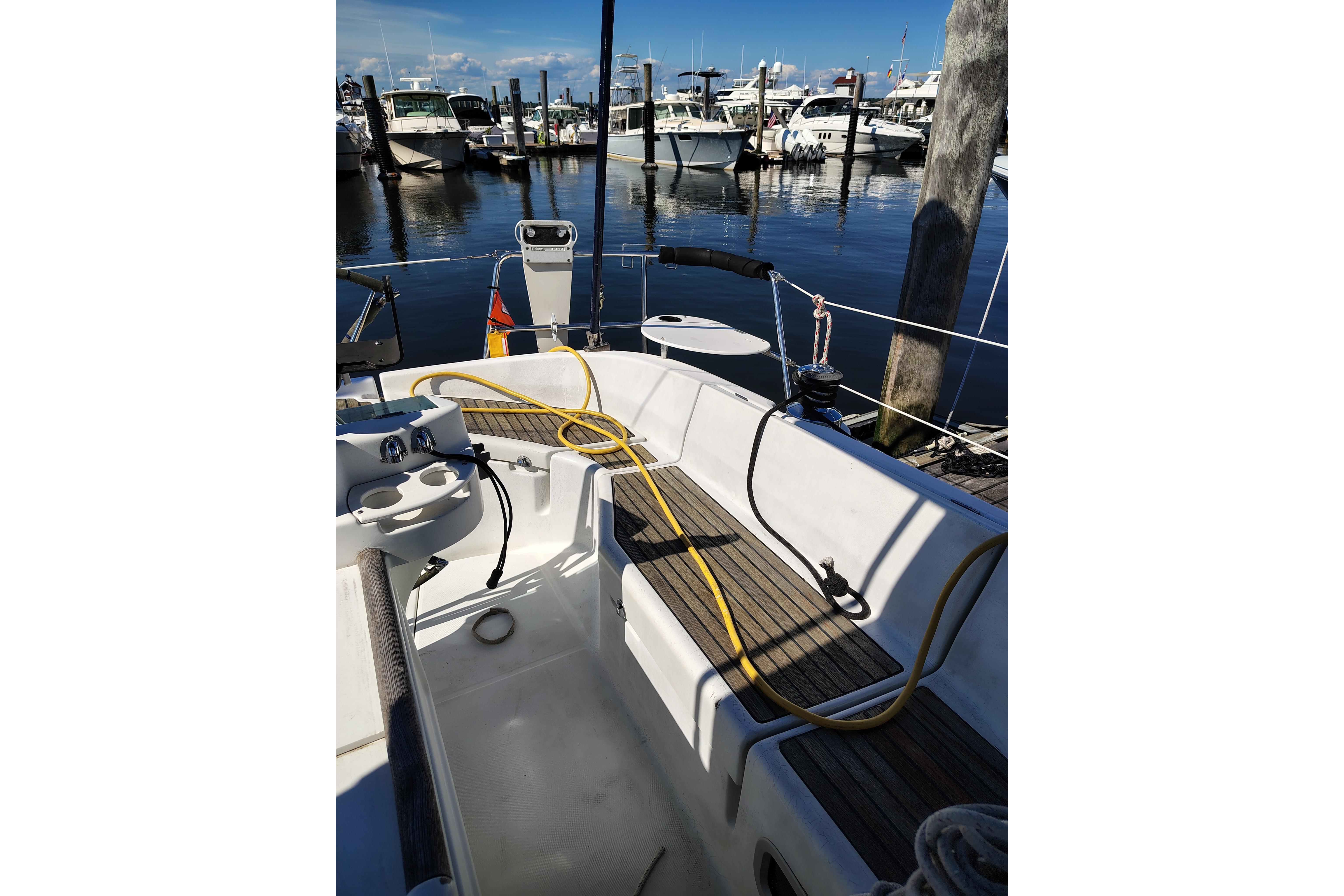 2001 Beneteau Oceanis 411 sailboat cockpit at marina, featuring seating and nautical equipment.