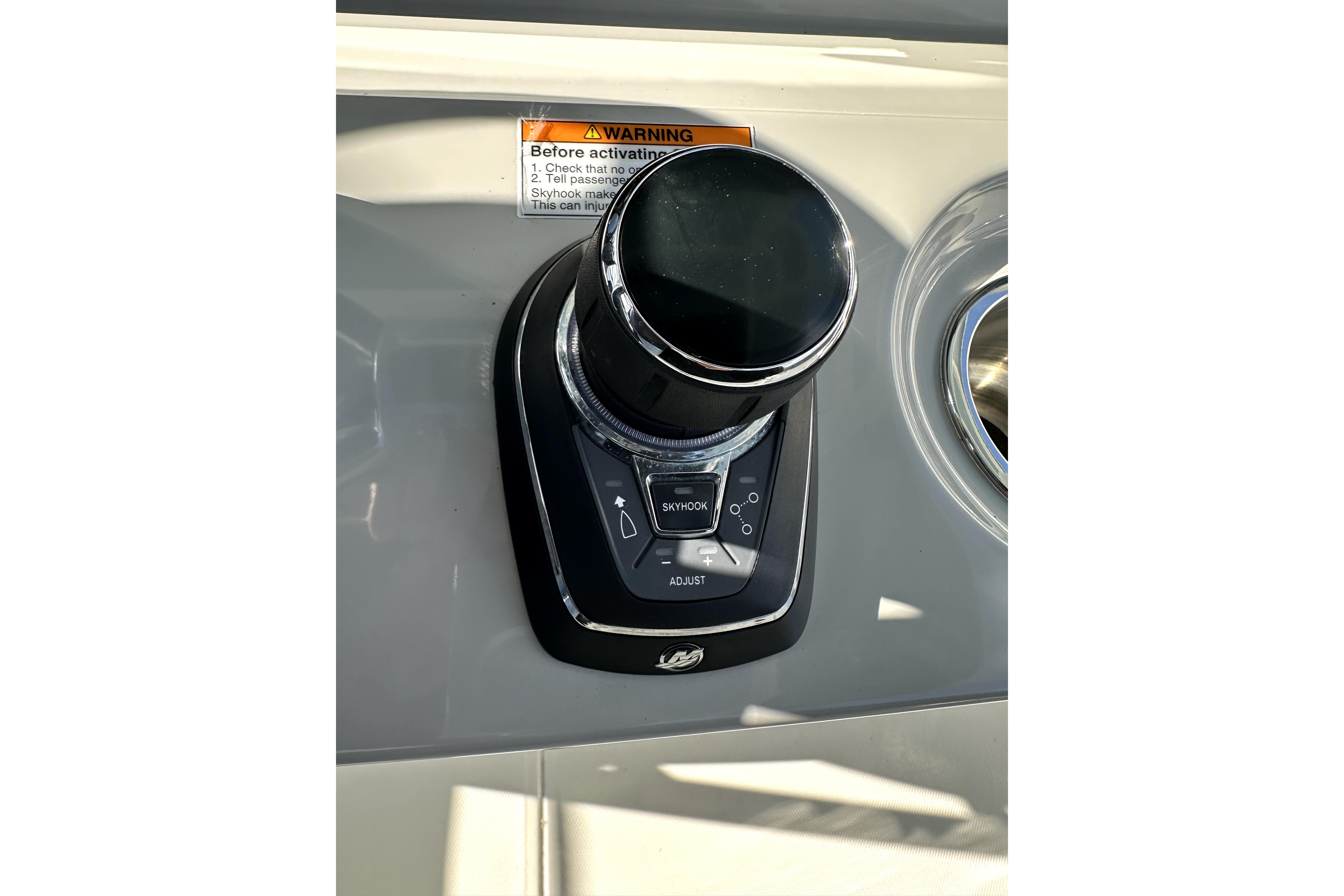 2023 Boston Whaler OUTRAGE boat control panel with joystick and warning label.