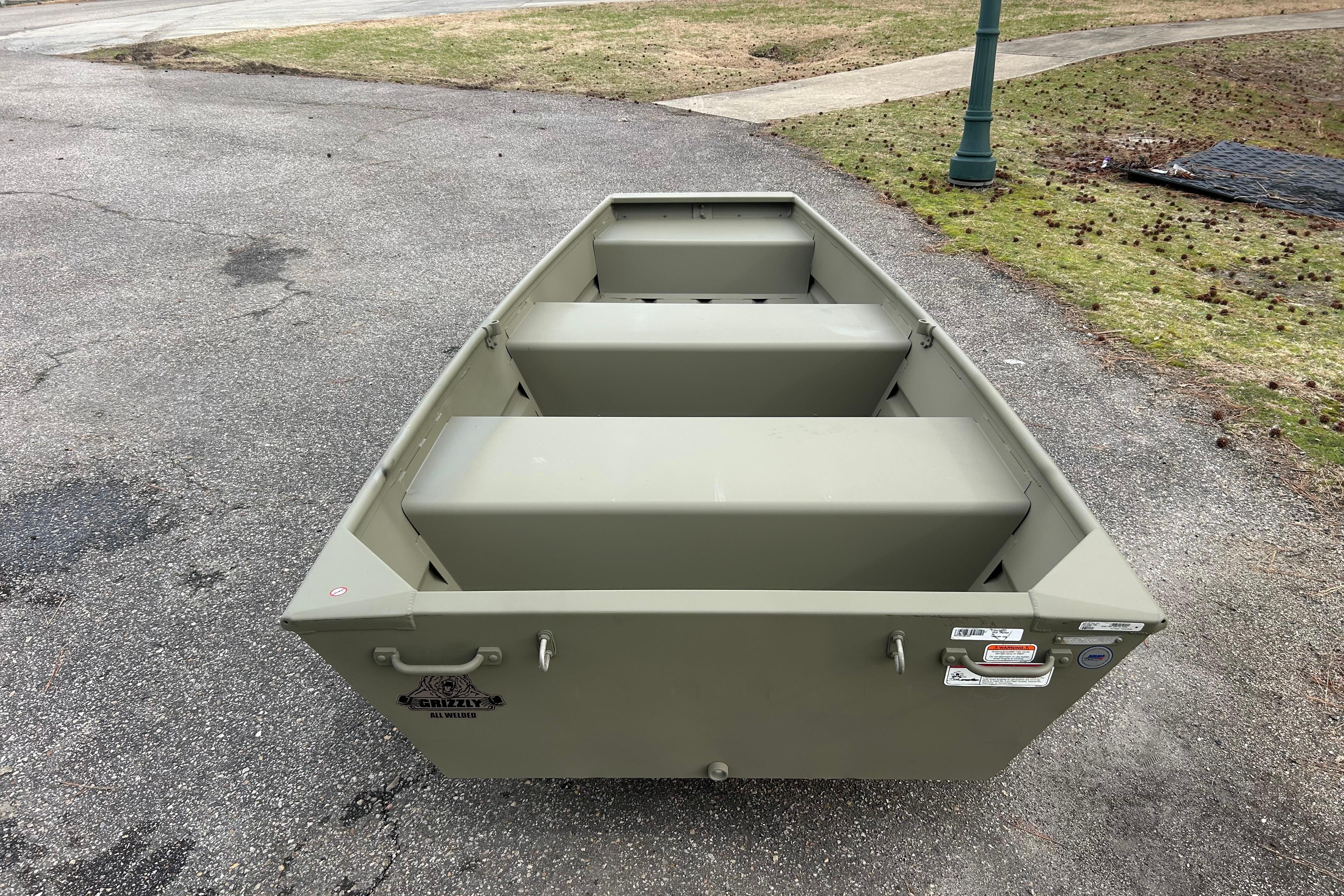 2026 Tracker Grizzly 10 Jon boat on pavement, showcasing its sturdy design and seating arrangement.