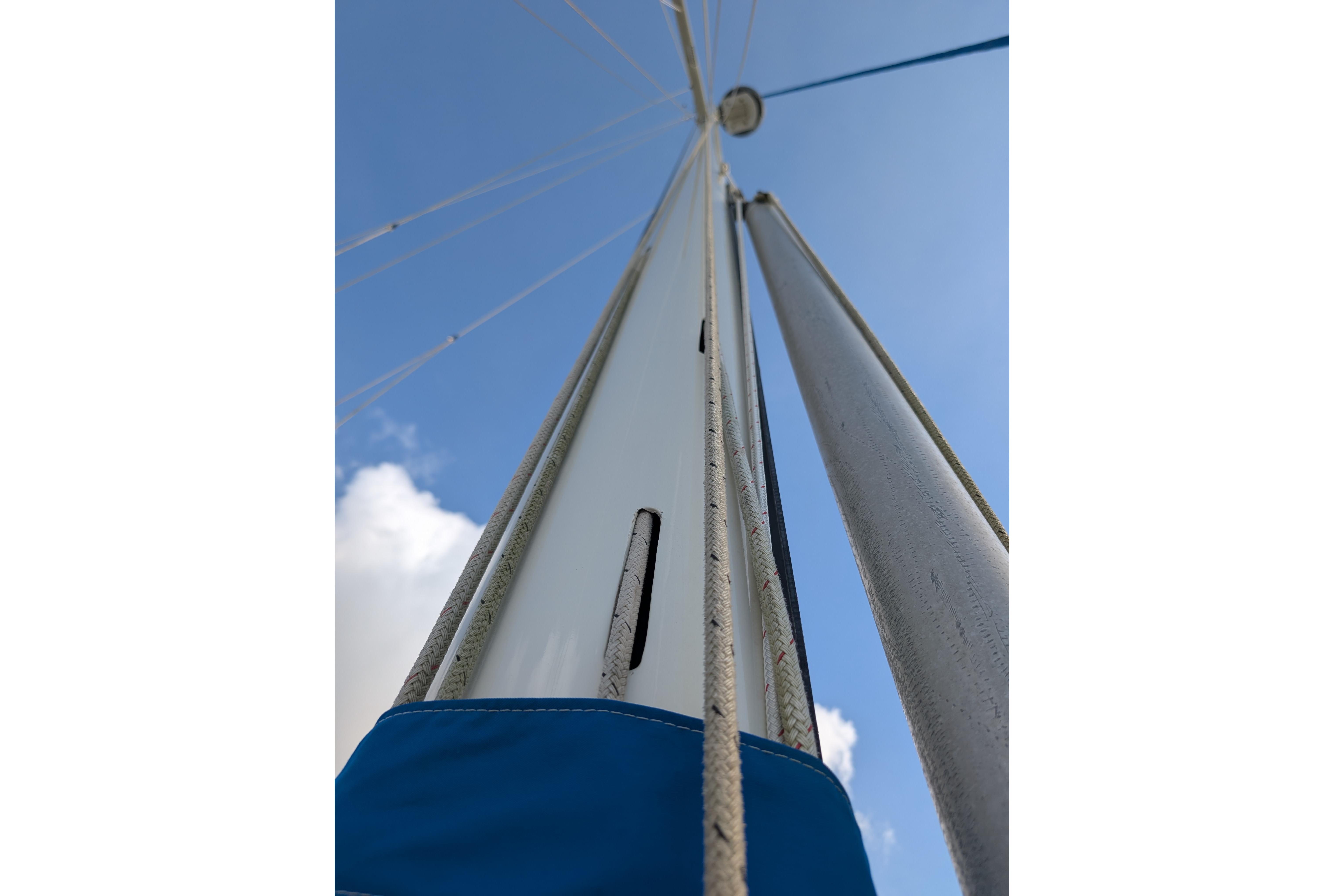 Mast and rigging of 1983 Robert Perry 41 sailboat against blue sky.