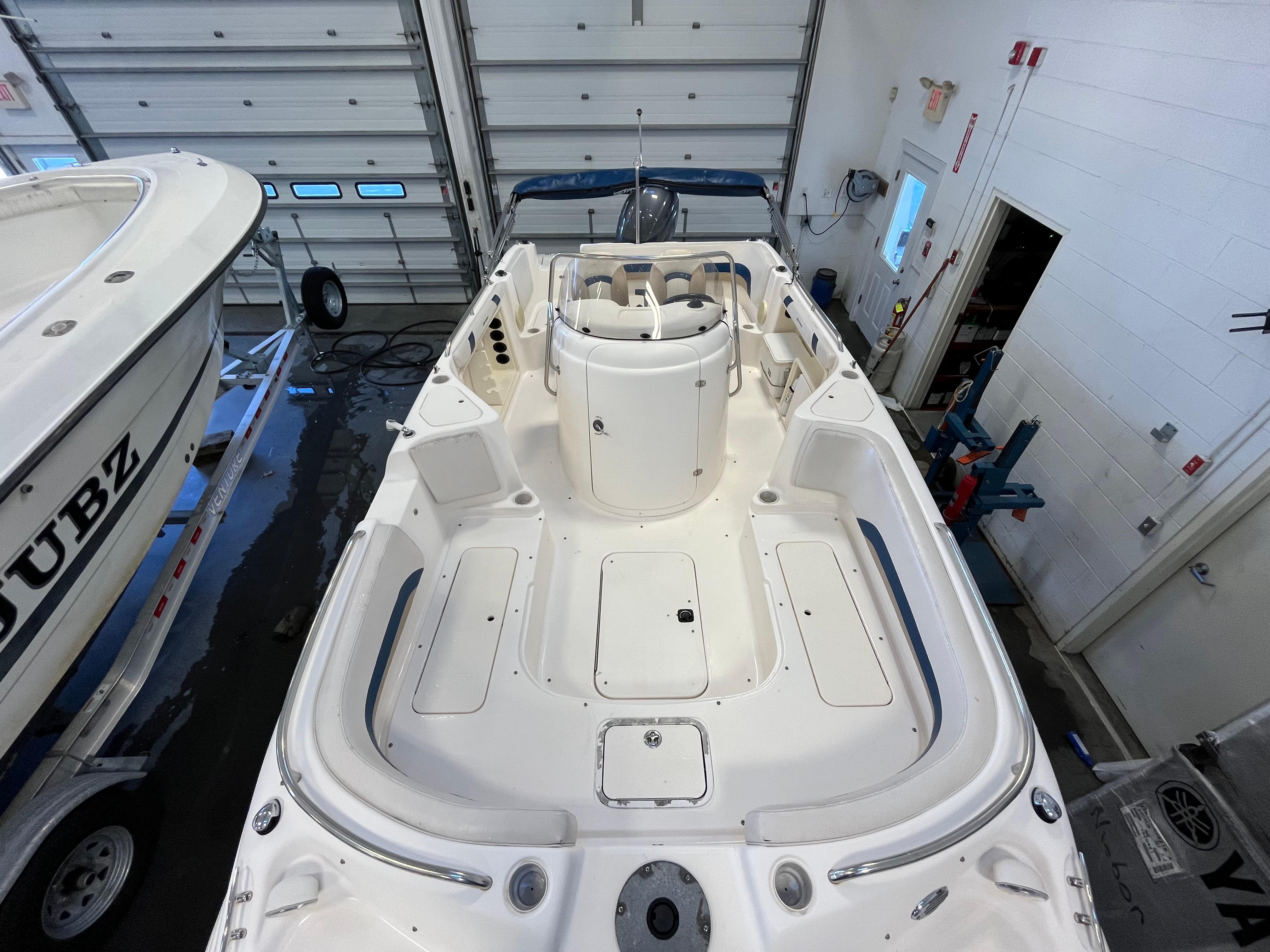 2005 Godfrey FD211 boat interior in a garage, showcasing spacious seating and storage areas.