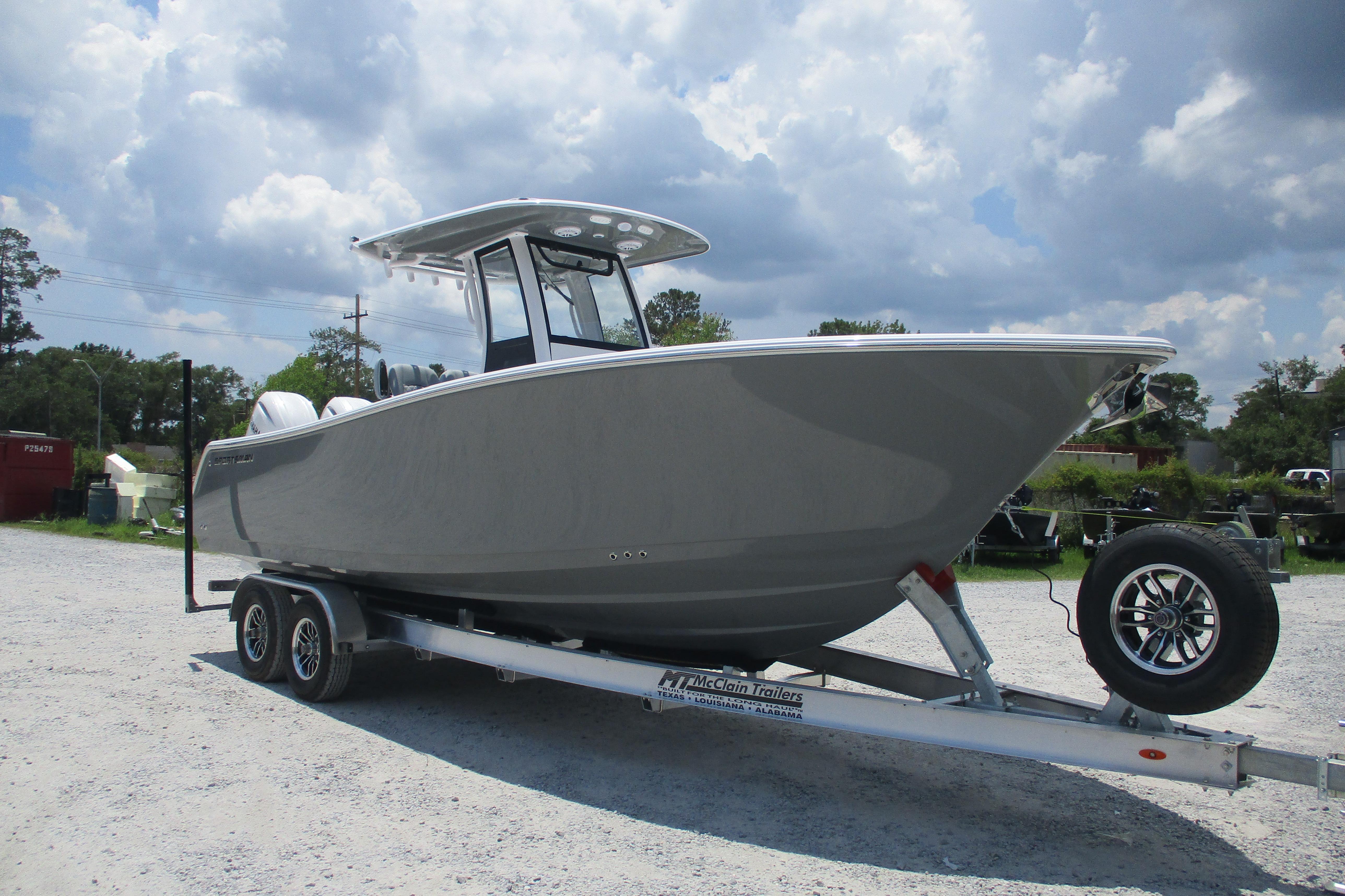 2027 Sportsman Open 252 Center Console boat on trailer under cloudy sky.