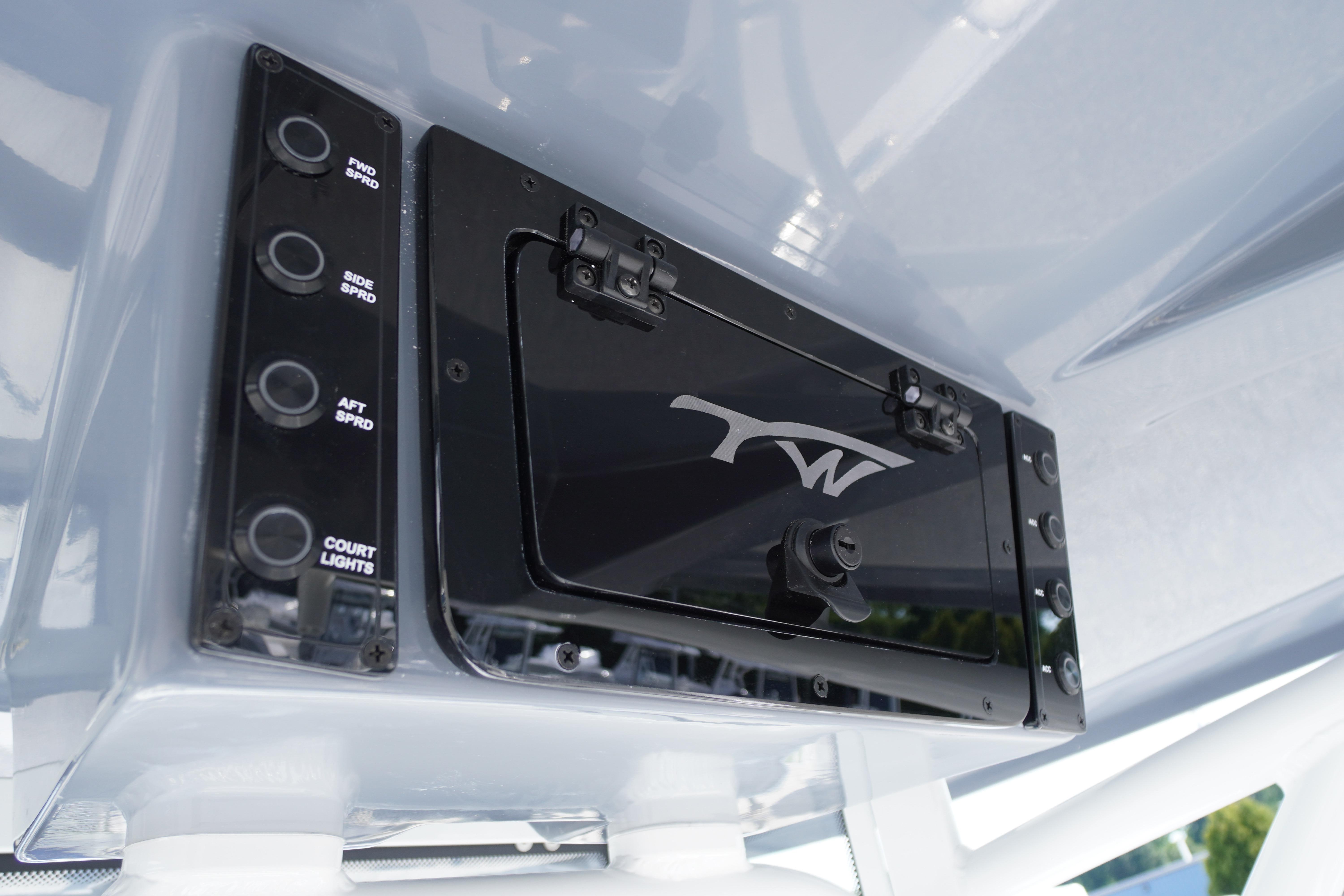 Control panel of 2026 Tidewater 220 CC Adventure boat with switches and logo.