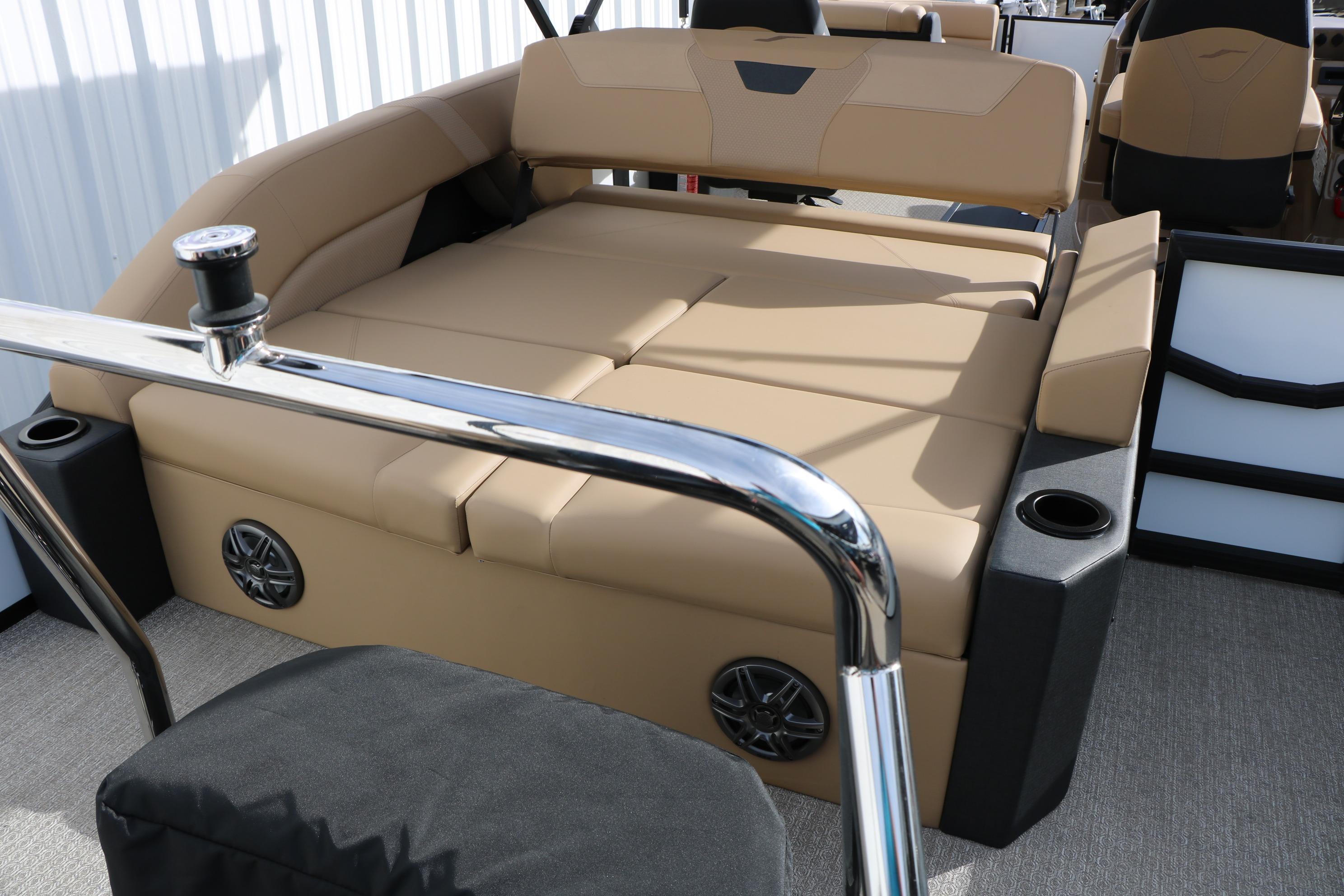 Luxurious seating area on 2026 Evotti 523CS boat with beige upholstery and cup holders.