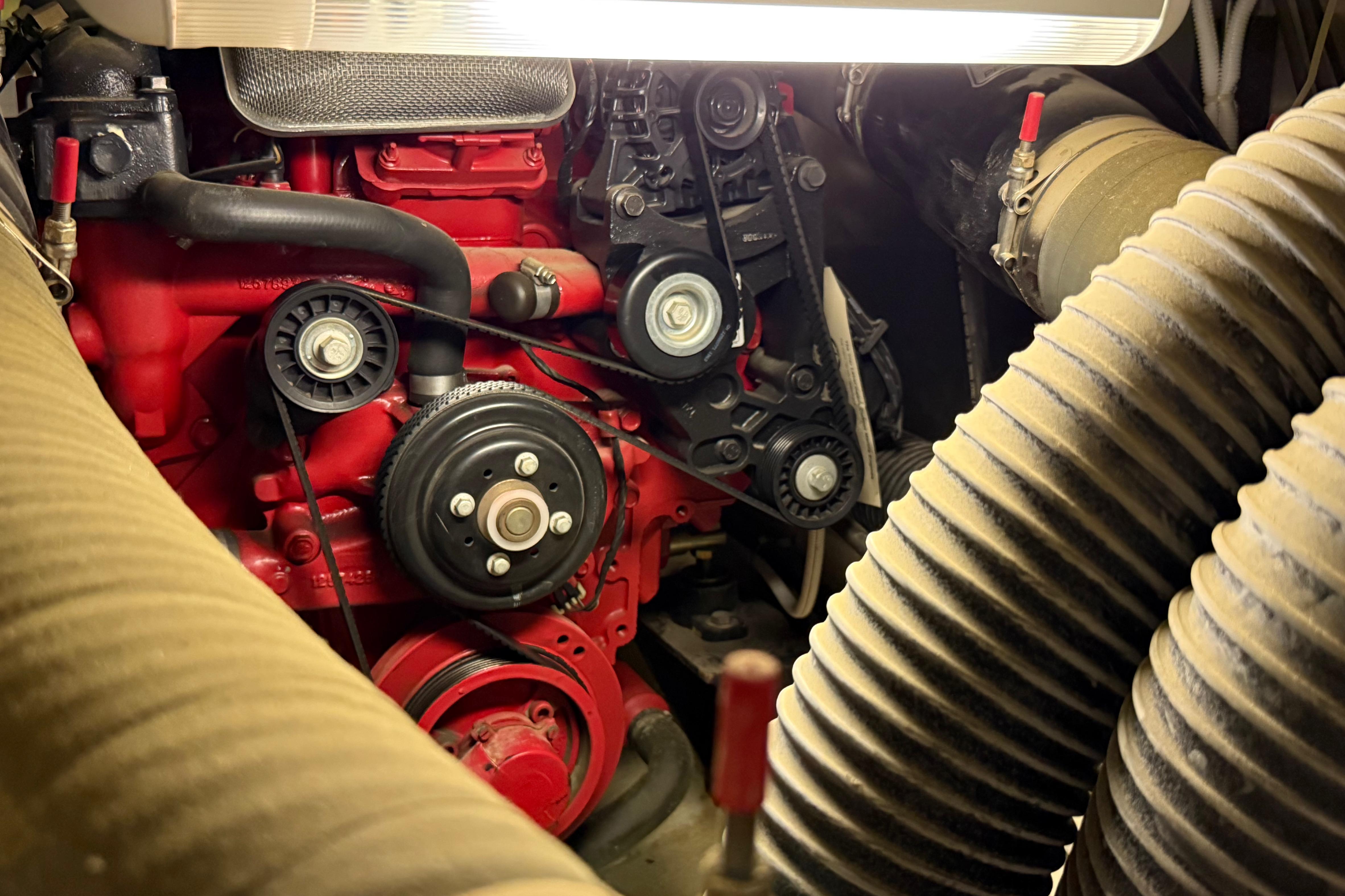 Engine compartment of a 2004 Carver 360 Sport Sedan, featuring red components and hoses.