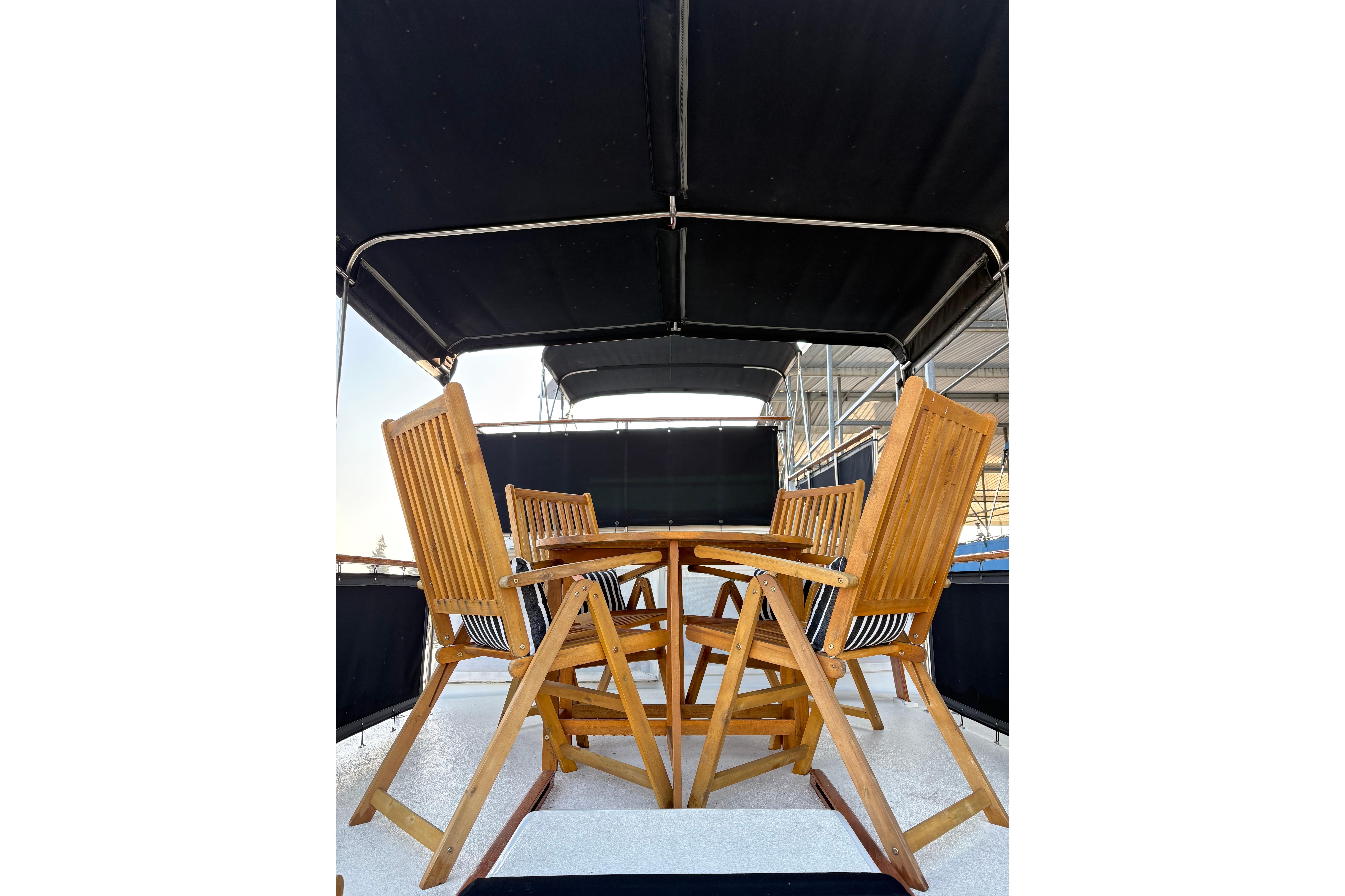 Outdoor wooden dining set on 1978 Californian 42 LRC yacht deck.