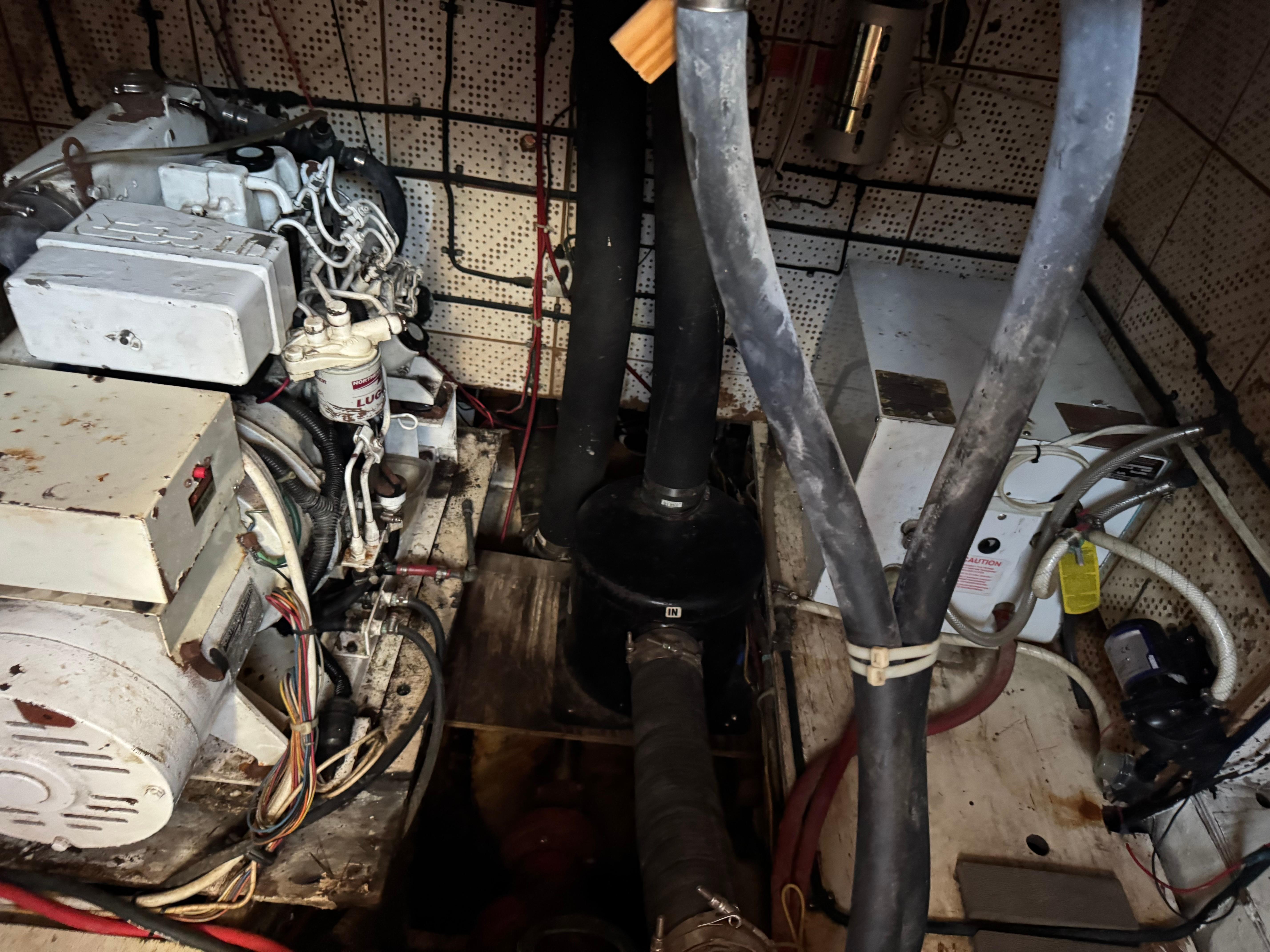 Engine room of 1983 Island Trader Motor Sailor with visible machinery and wiring.