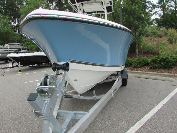 2023 Mako 214 CC boat on trailer, blue hull, parked outdoors.