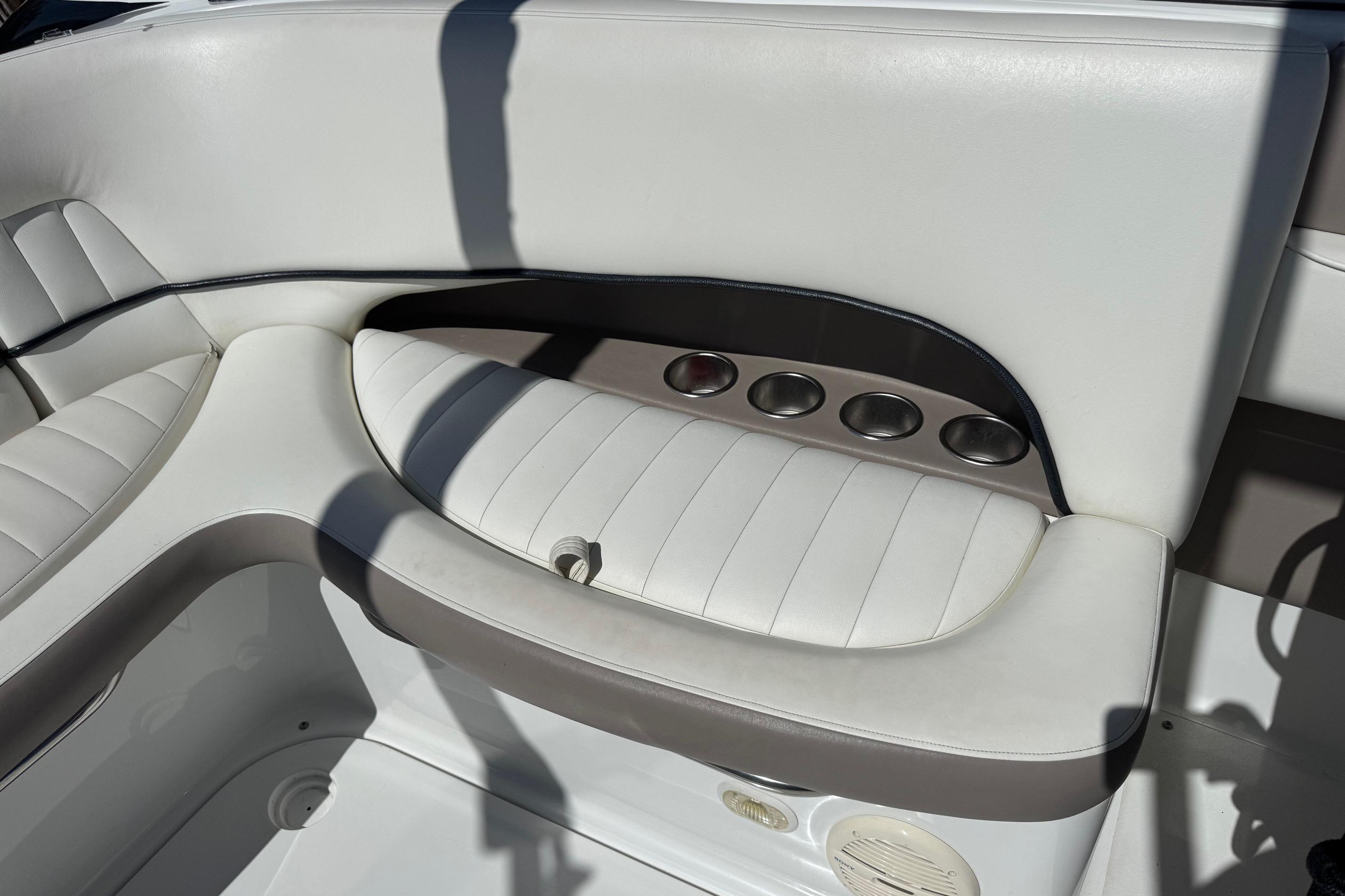 2005 Cobalt 240 boat interior with white cushioned seating and cup holders.