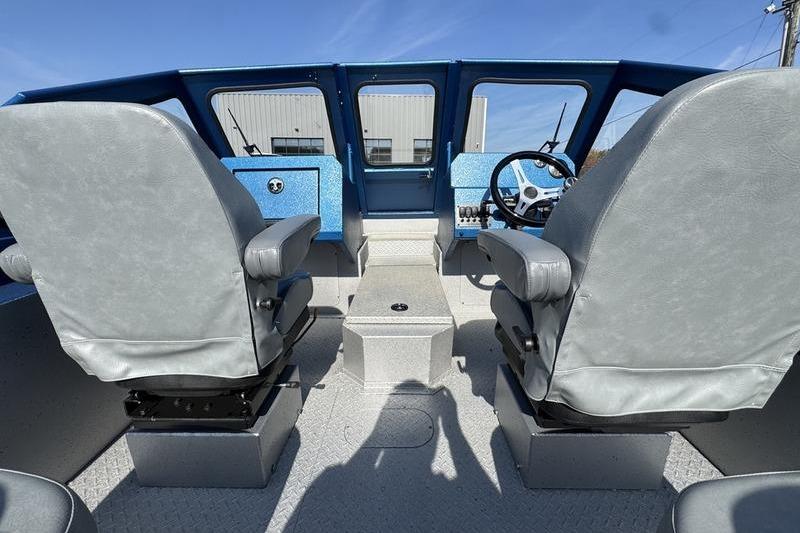 Interior of 2026 SeaArk Dynasty 2.0 boat with dual seats and steering console.