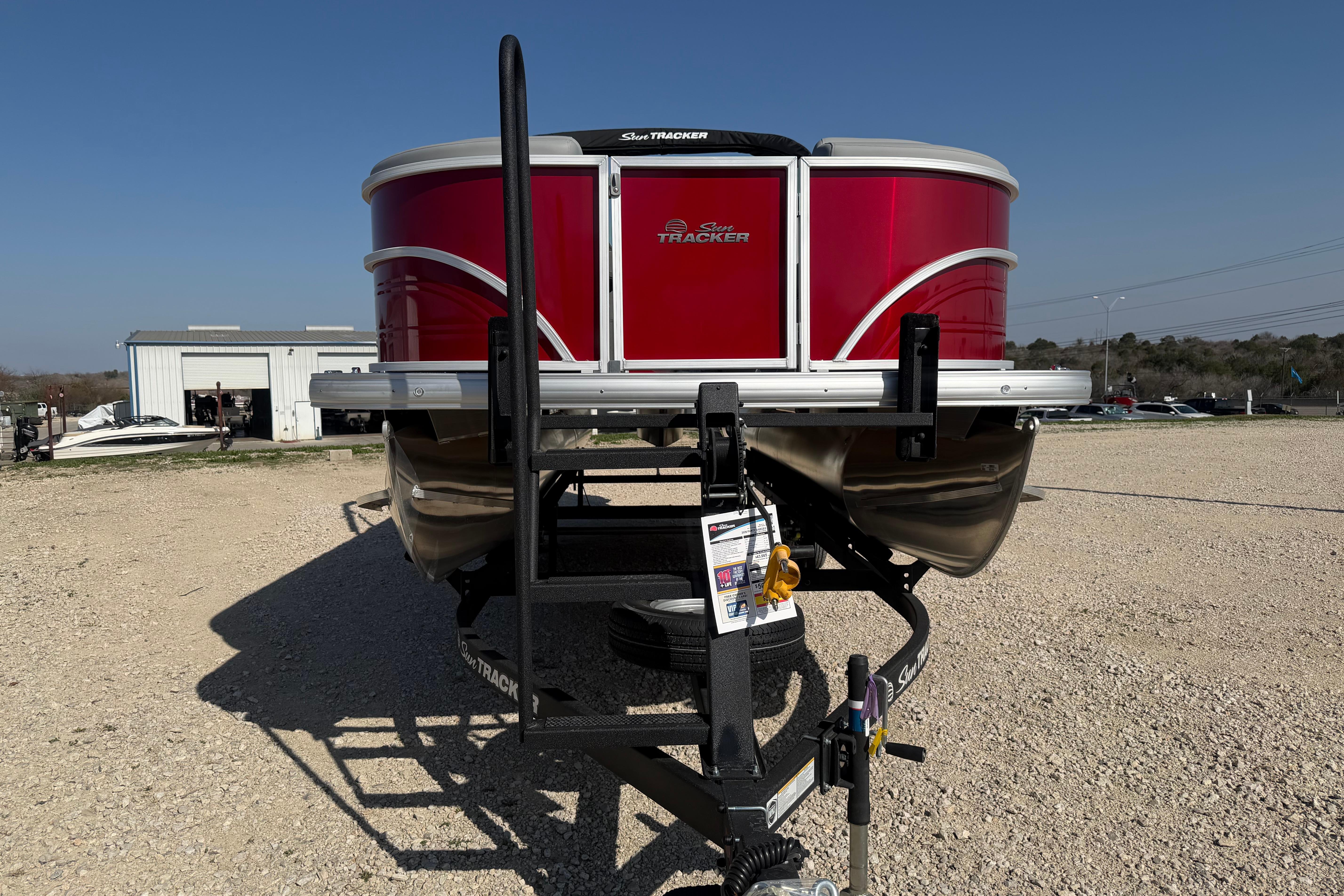 2026 Sun Tracker Party Barge 22 DLX pontoon boat on trailer, red exterior.