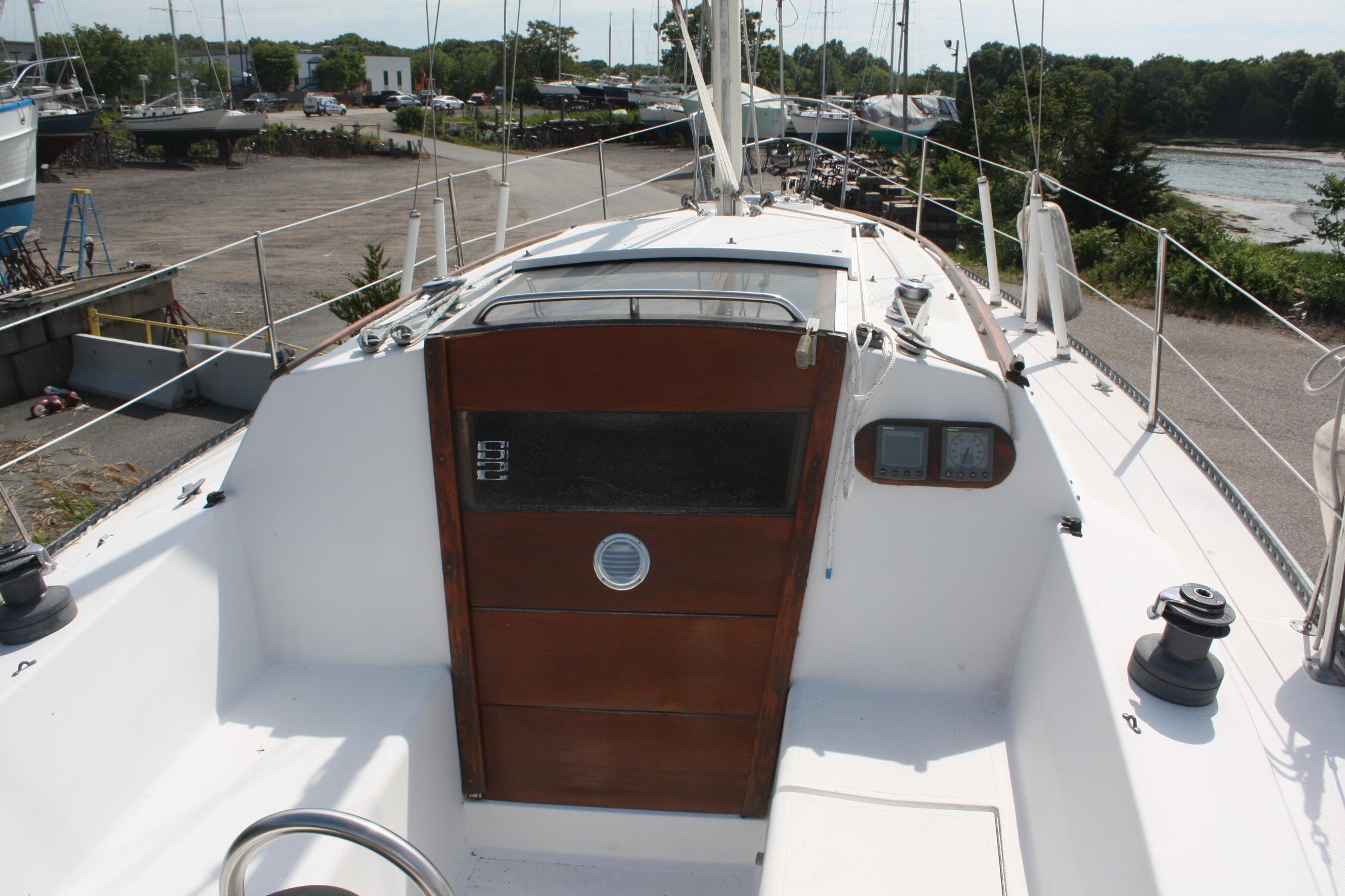 1981 S2 9.2A sailboat cockpit with wooden hatch, docked in a marina setting.