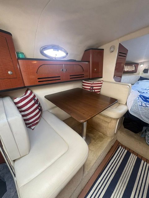 Interior of Sea Ray Sundancer 280 featuring a seating area and wooden table.