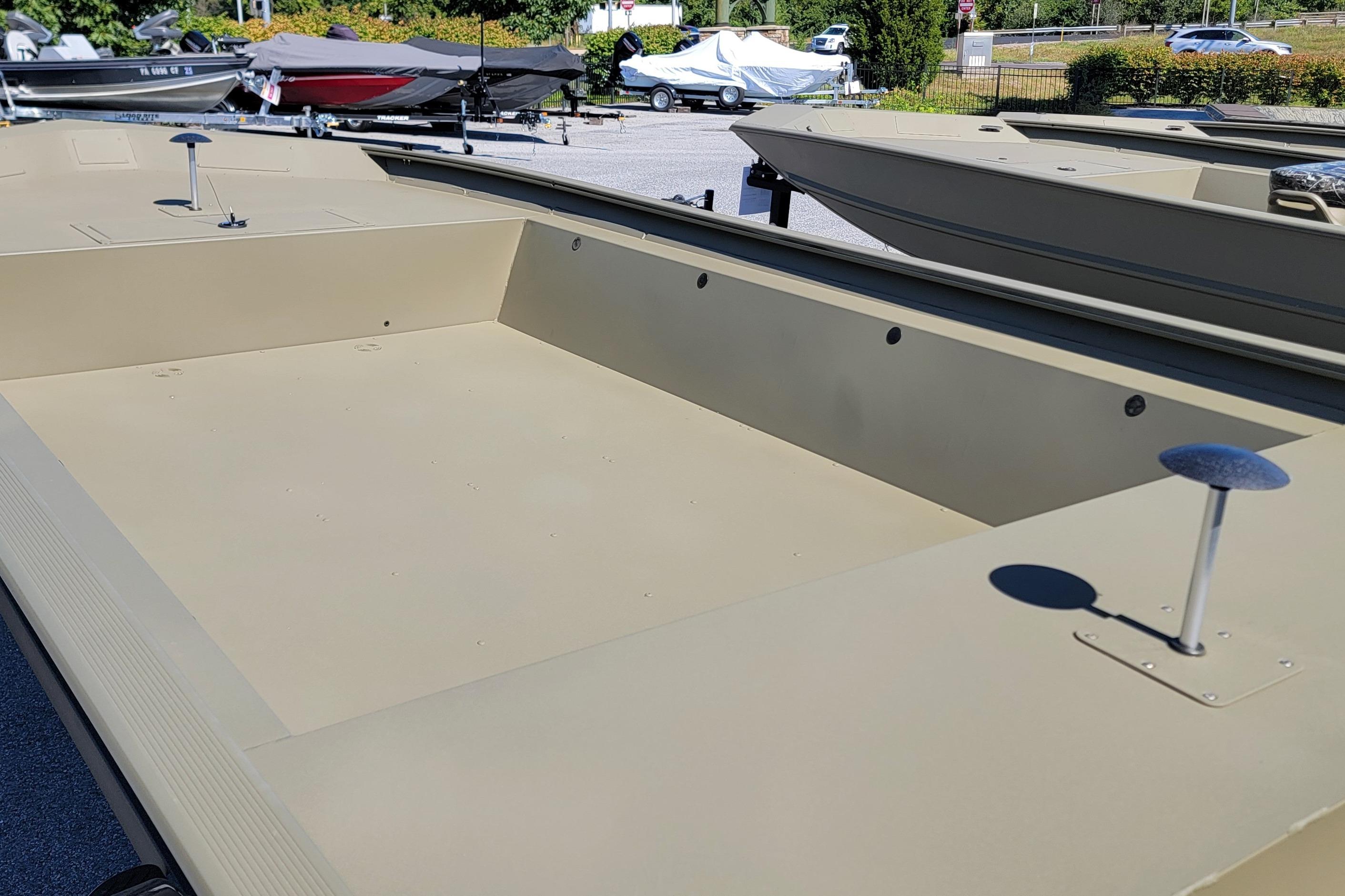 2026 Tracker Grizzly 1860 Utility boat, beige deck, parked outdoors in a marina.