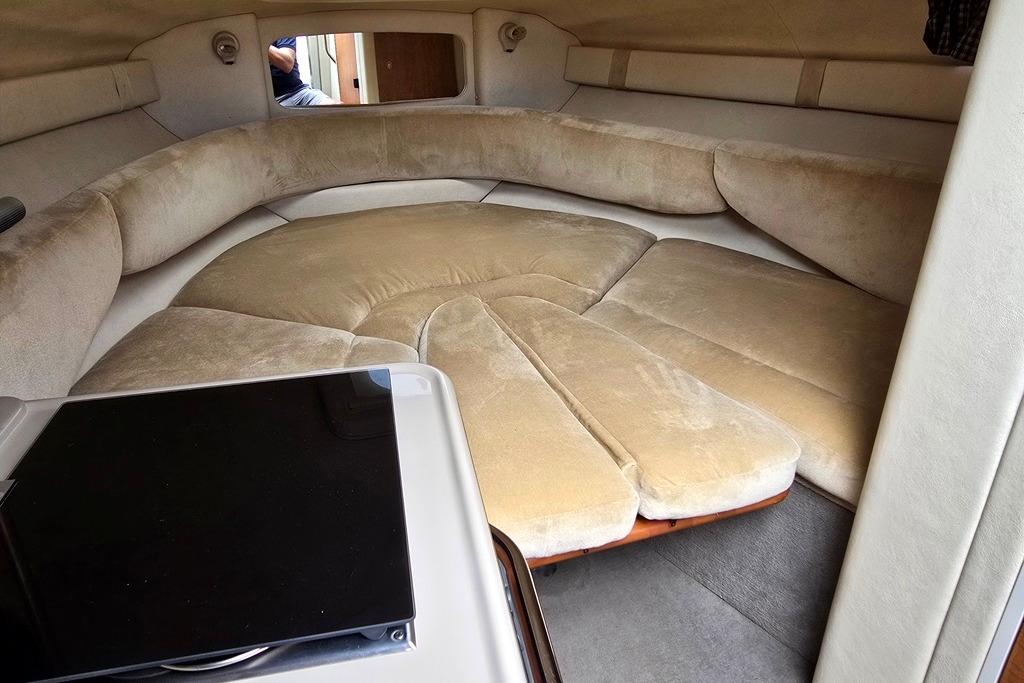Interior cabin of a 2006 Sea Ray 240 Sundancer with beige seating and compact design.
