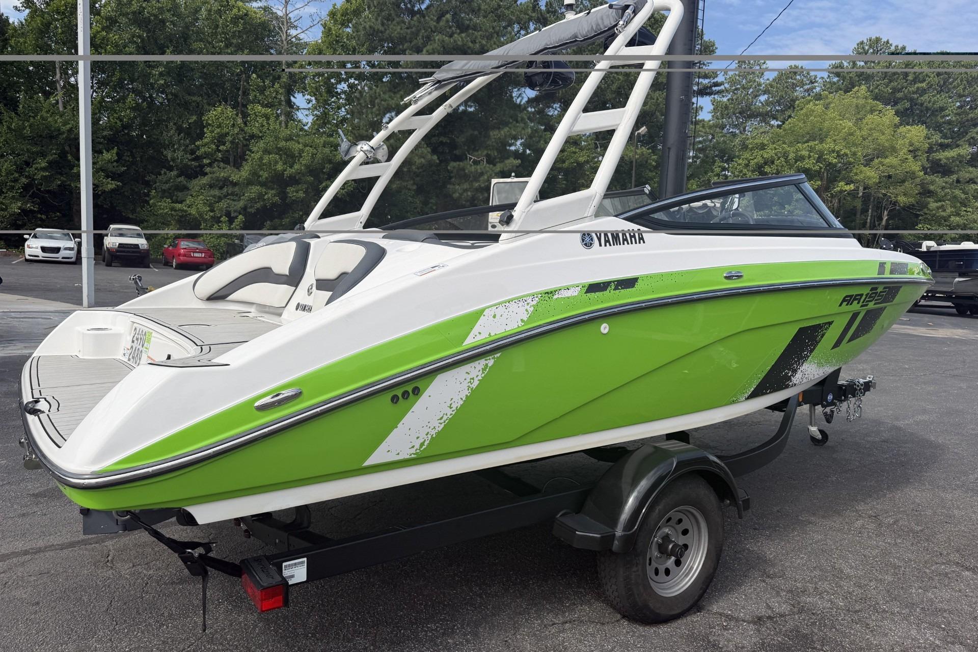 2022 Yamaha Boats AR195 in vibrant green on a trailer, parked outdoors.
