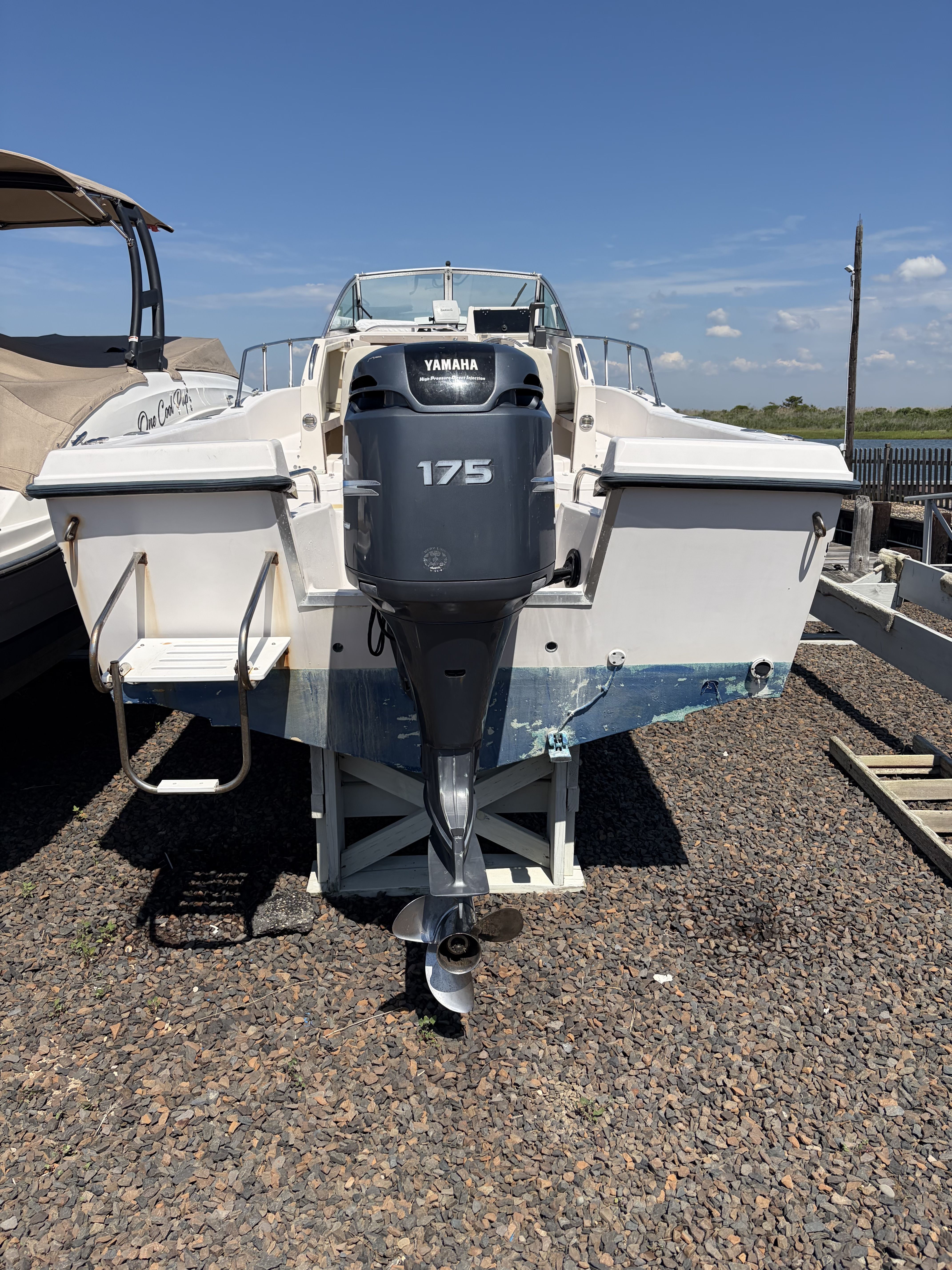 A 1993 Grady-White Adventure 208 boat on a gravel lot. It features a Yamaha 175 outboard motor.