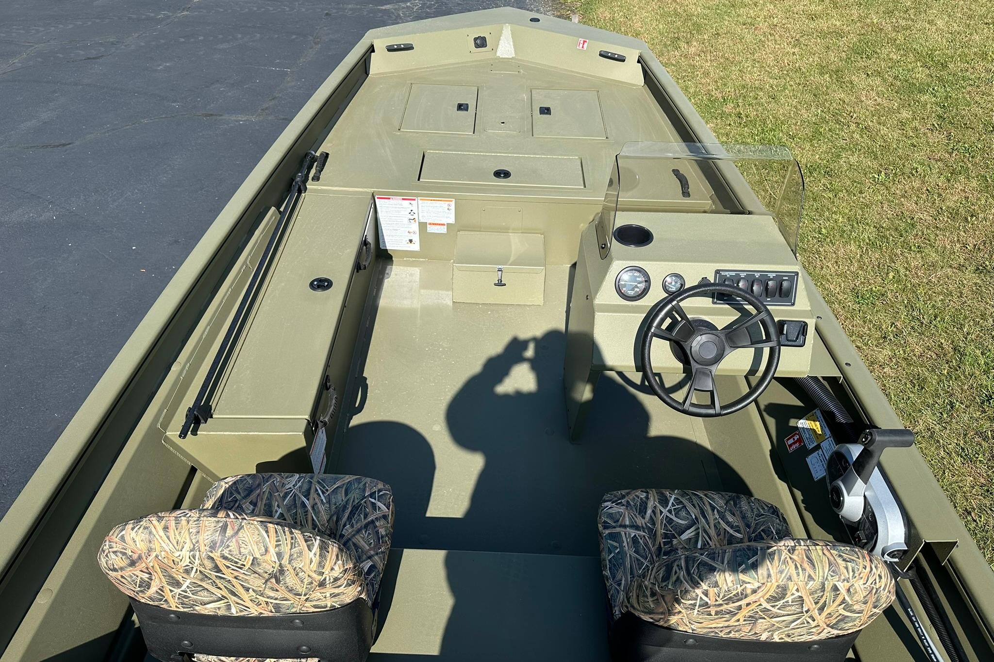 2026 Lowe Roughneck 1860SC boat interior with camo seats and steering console.