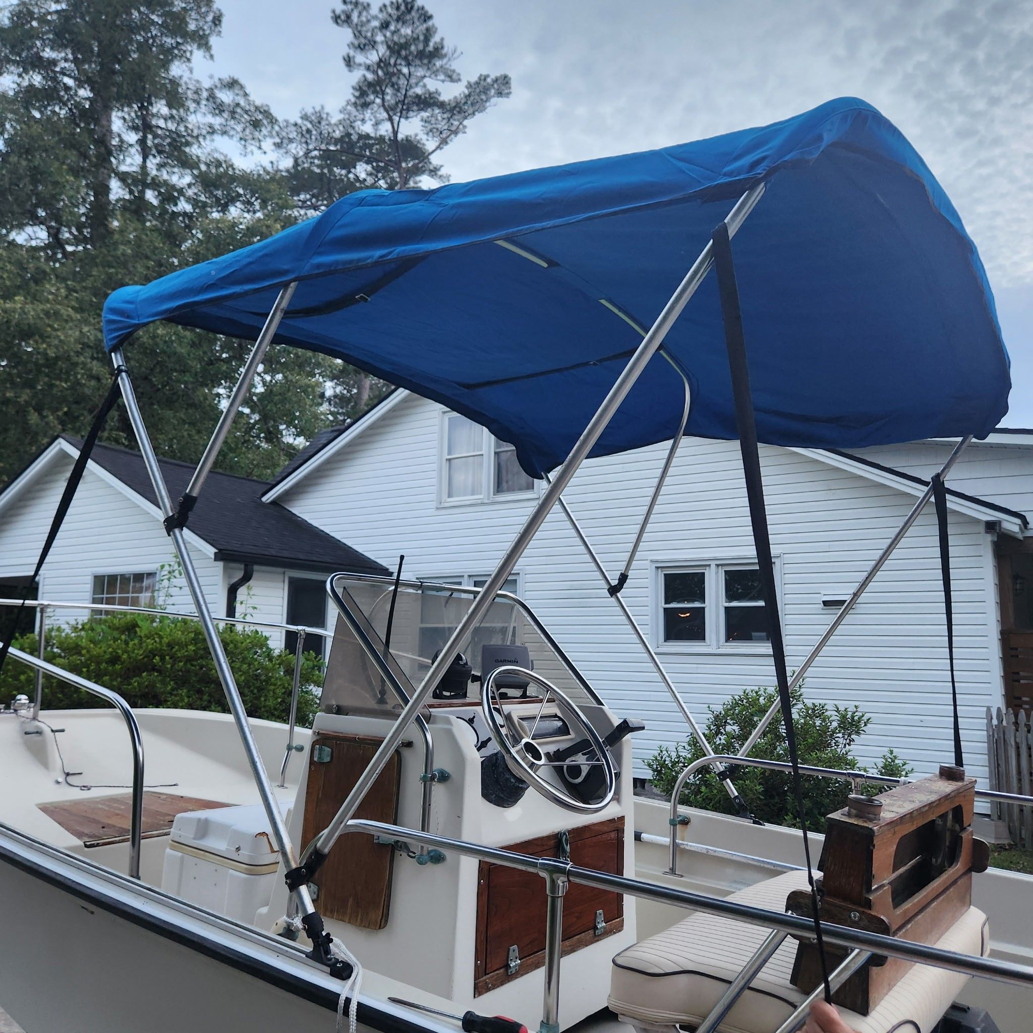 A 1976 Boston Whaler MONTAUK with a blue sunshade and steering console.