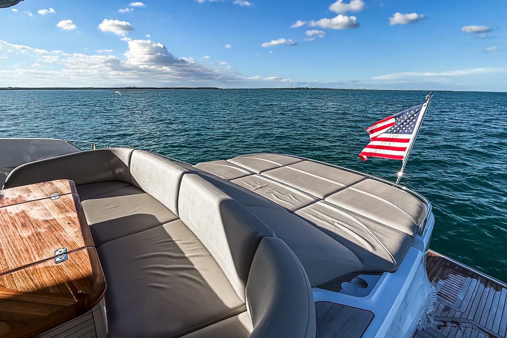 Luxurious 2026 Princess S65 Sportbridge yacht with American flag, ocean view.