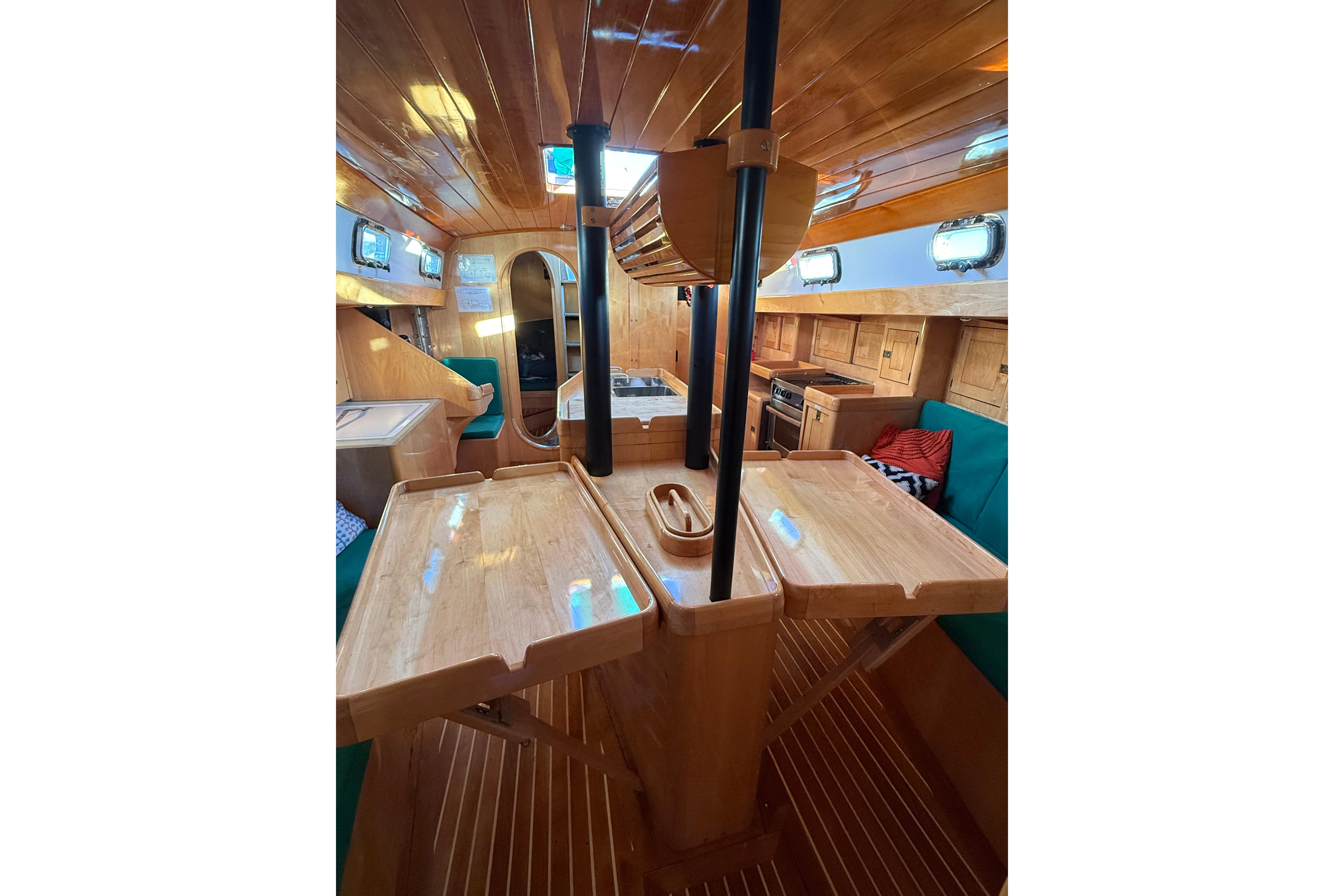 Interior of 2007 Chuck Burns Custom 49' Schooner with wooden finishes and cozy seating.