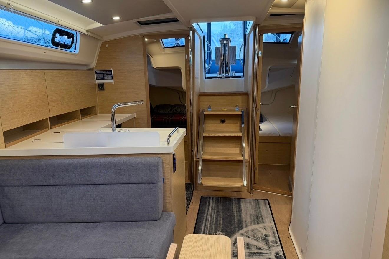 Modern interior of 2022 Hanse 418 yacht with sleek kitchen and cozy seating area.
