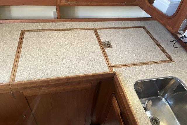 1995 Hunter Legend 40.5 yacht kitchen with wooden cabinetry and stainless steel sink.
